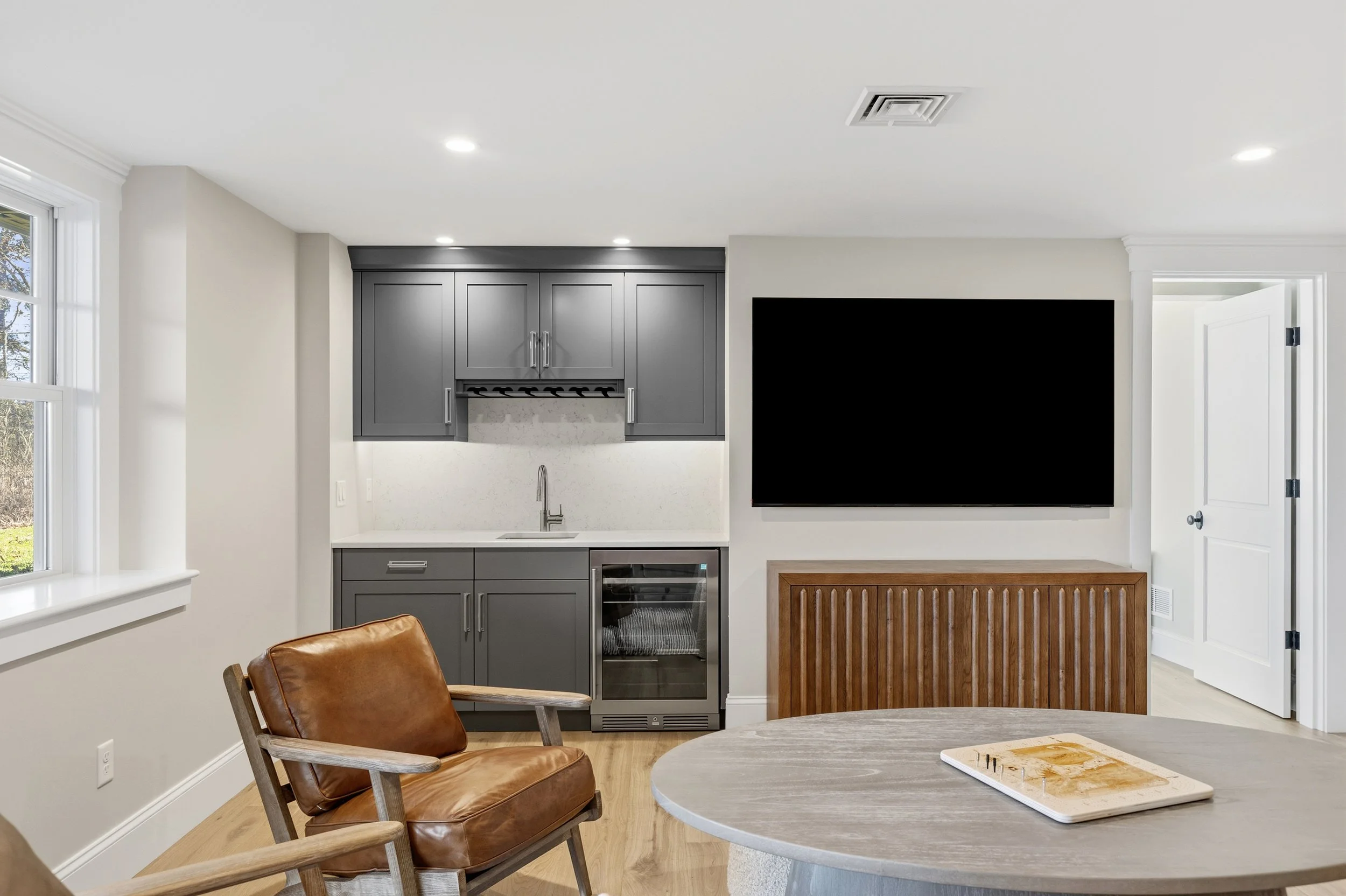 lower level wet bar with custom cabinetry, gray finish