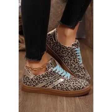 Person wearing leopard print sneakers with light blue laces, paired with black pants, and a gold ankle chain.