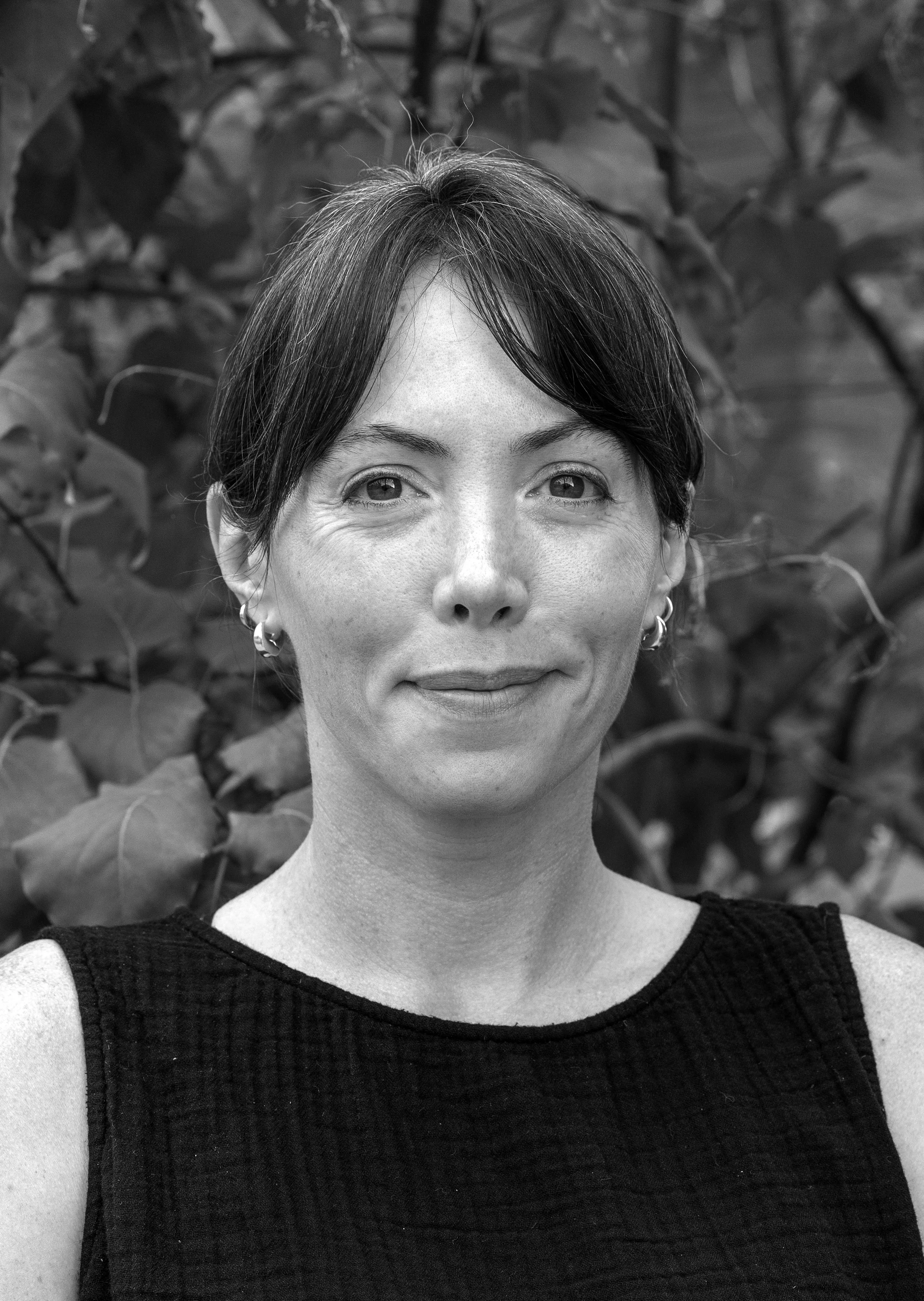 Laura Keating, associate at Ascend Group, with short dark hair, wearing a sleeveless black top outdoors.
