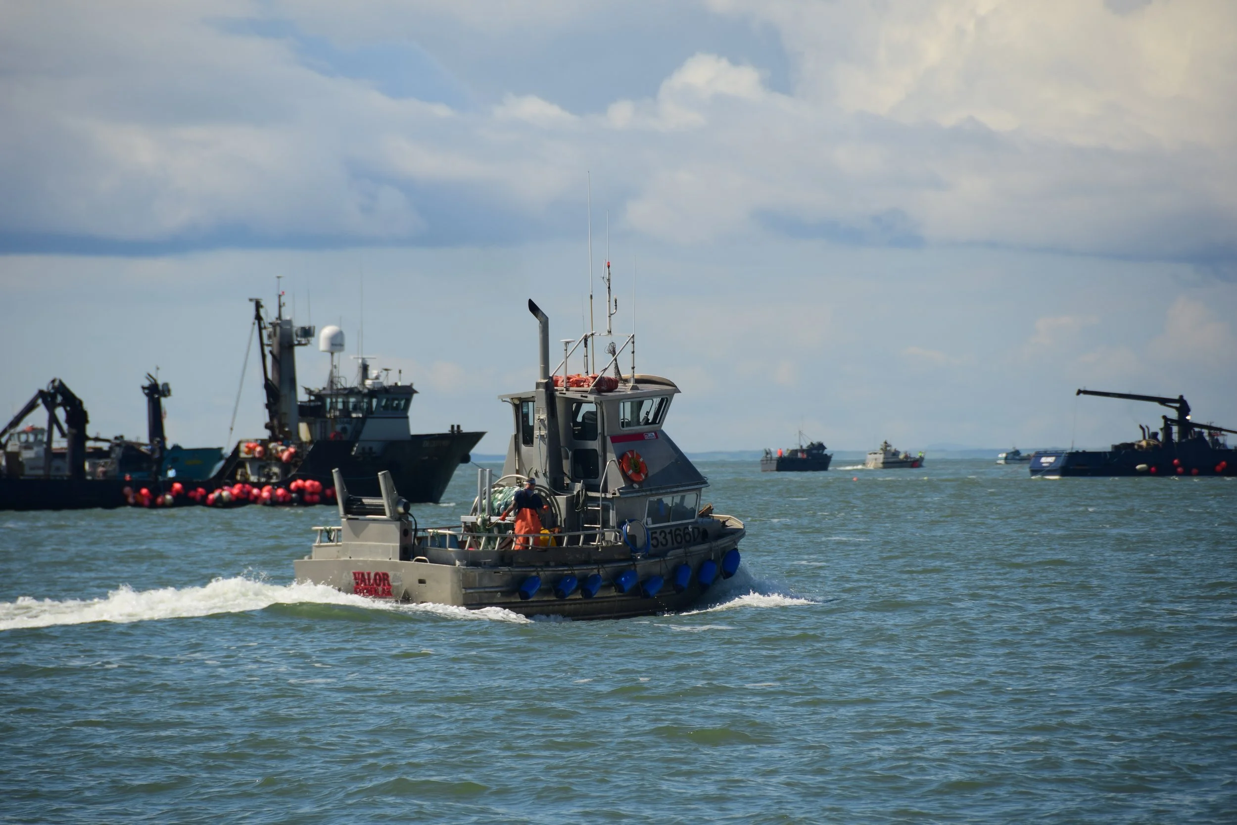 A commercial fishing vessel in Bristol Bay between larger tender vessels