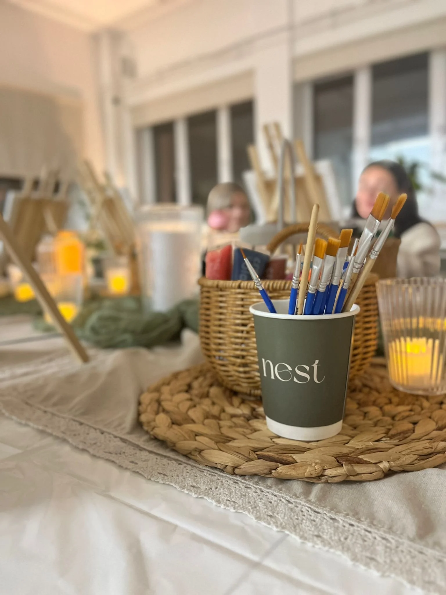 Nest paper cup with paintbrushes and cosy environment in the background during an art meditation workshop in Glasgow