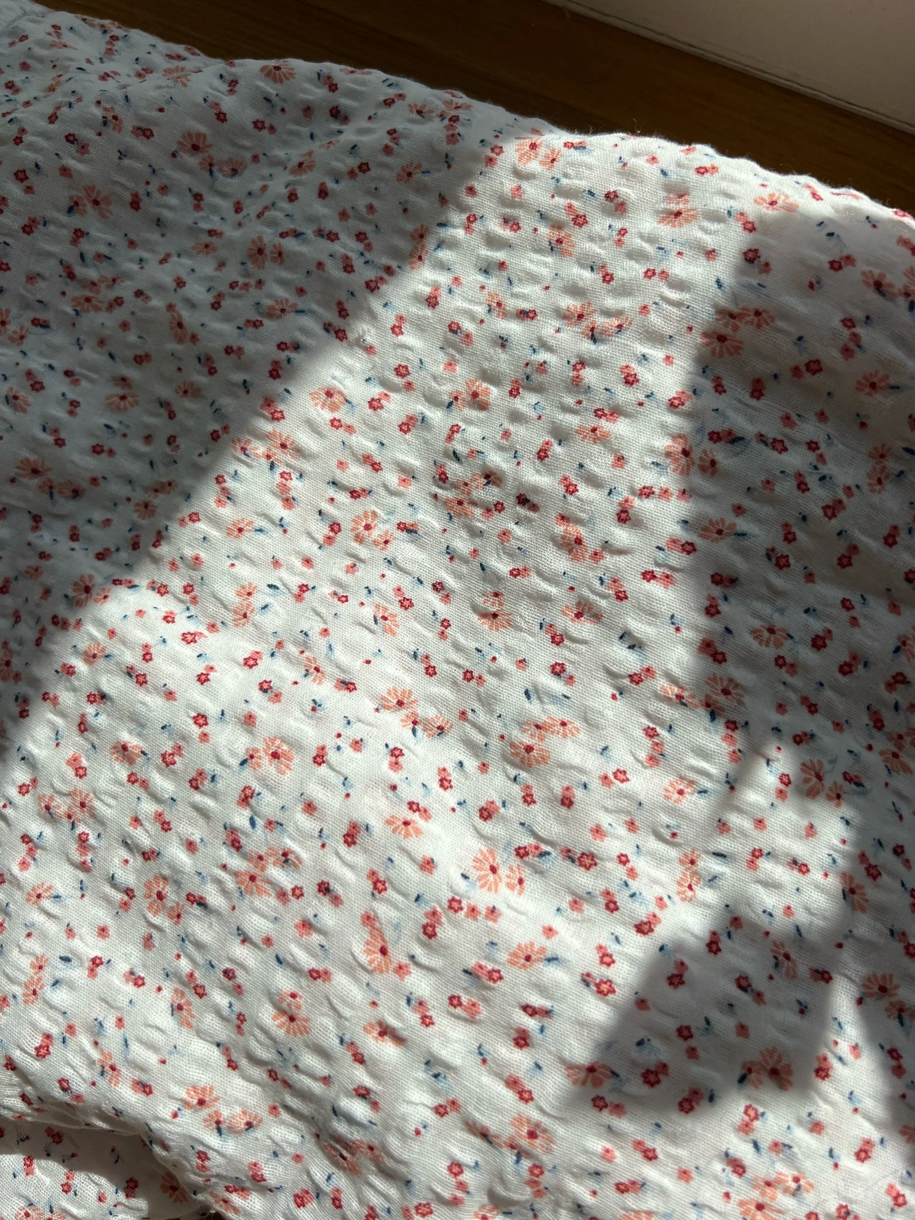 Hvit krepp med små rosa og blå blomster (100% bomull)