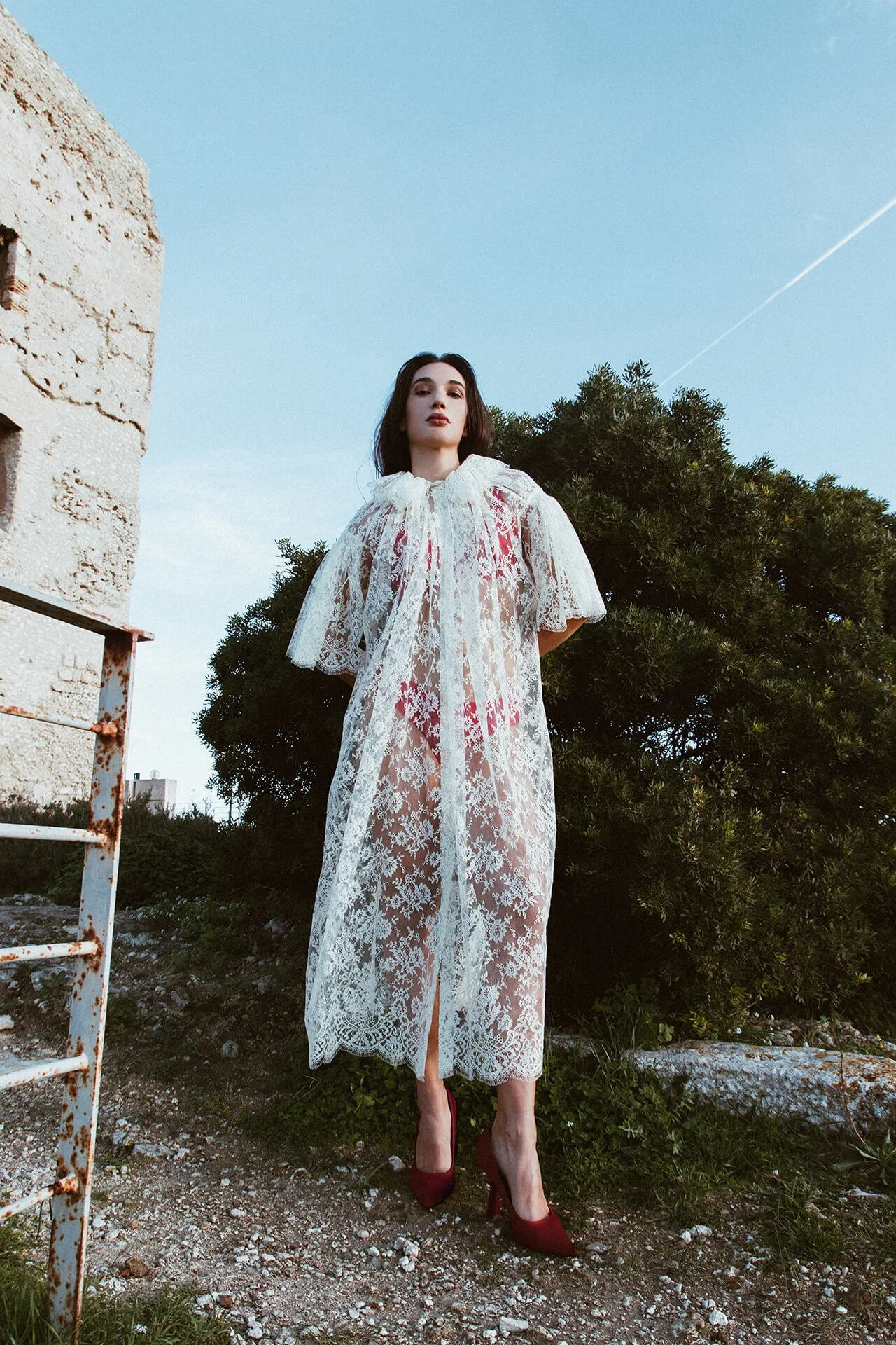 Modella con i capelli scuri con un vestito bianco ricamato