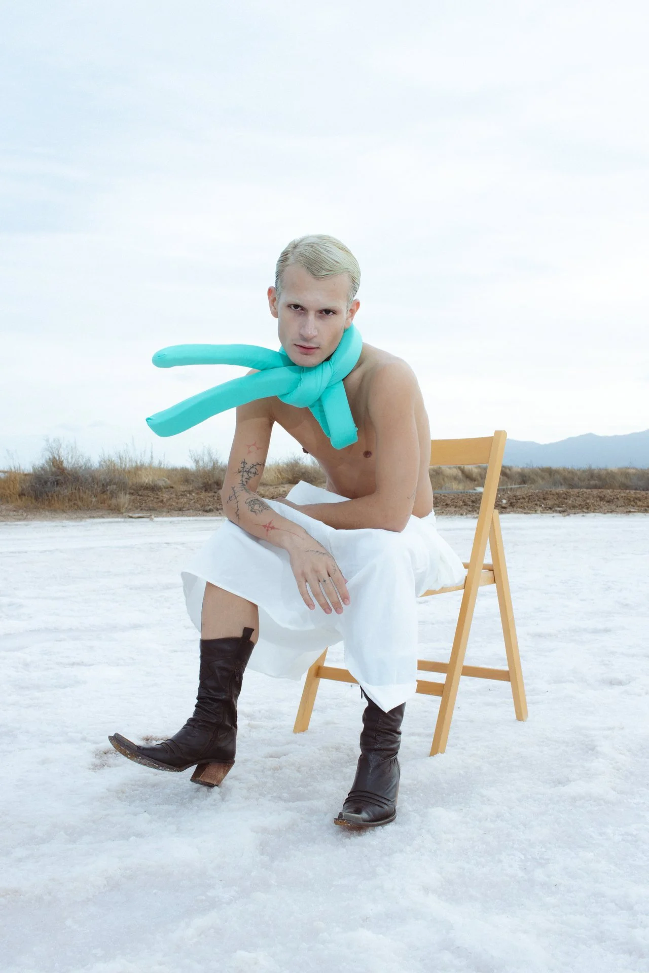 Portrait of a blonde young man sitting on a chair