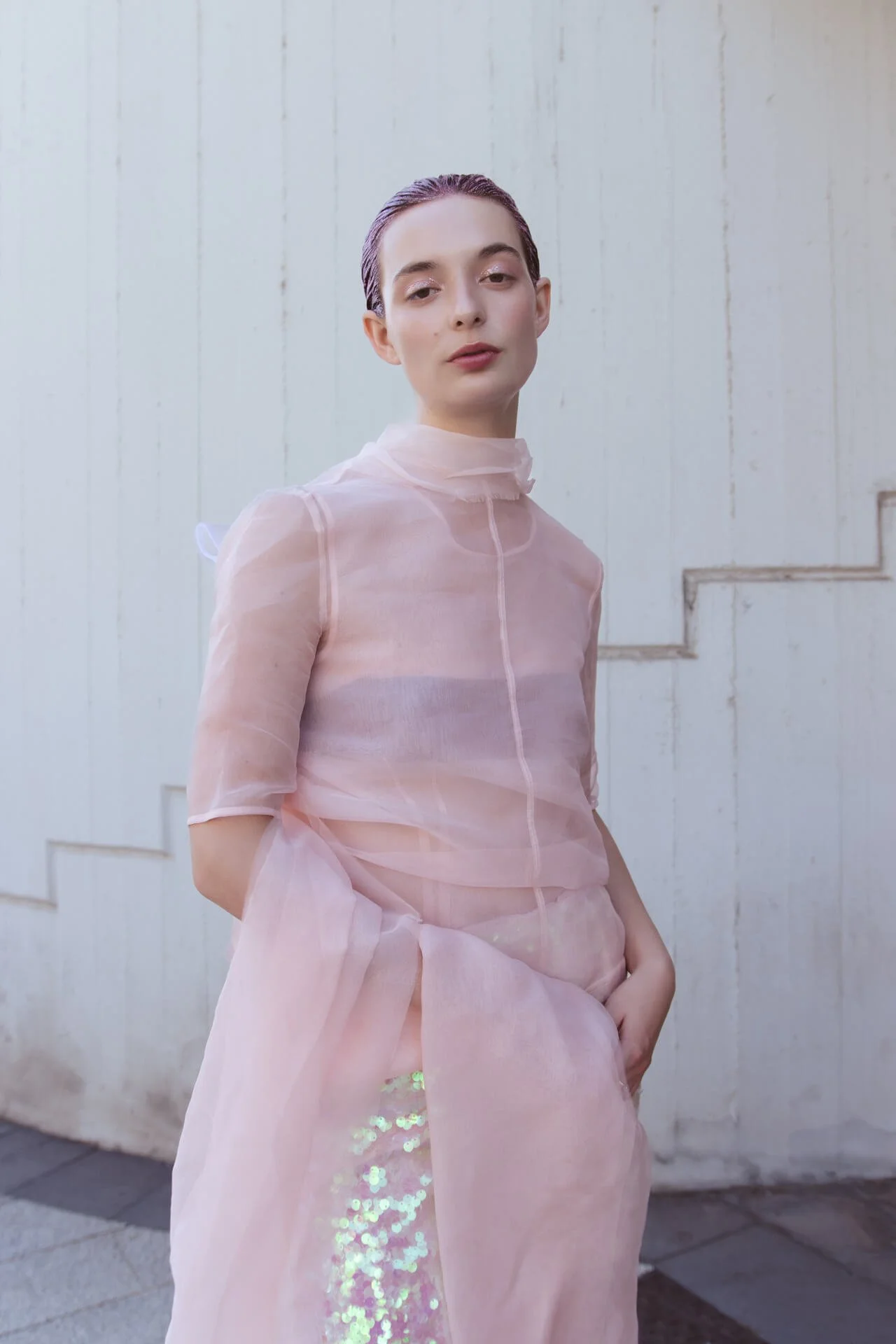 Piano americano di una ragazza vestita di rosa e una gonna su uno sfondo urbano
