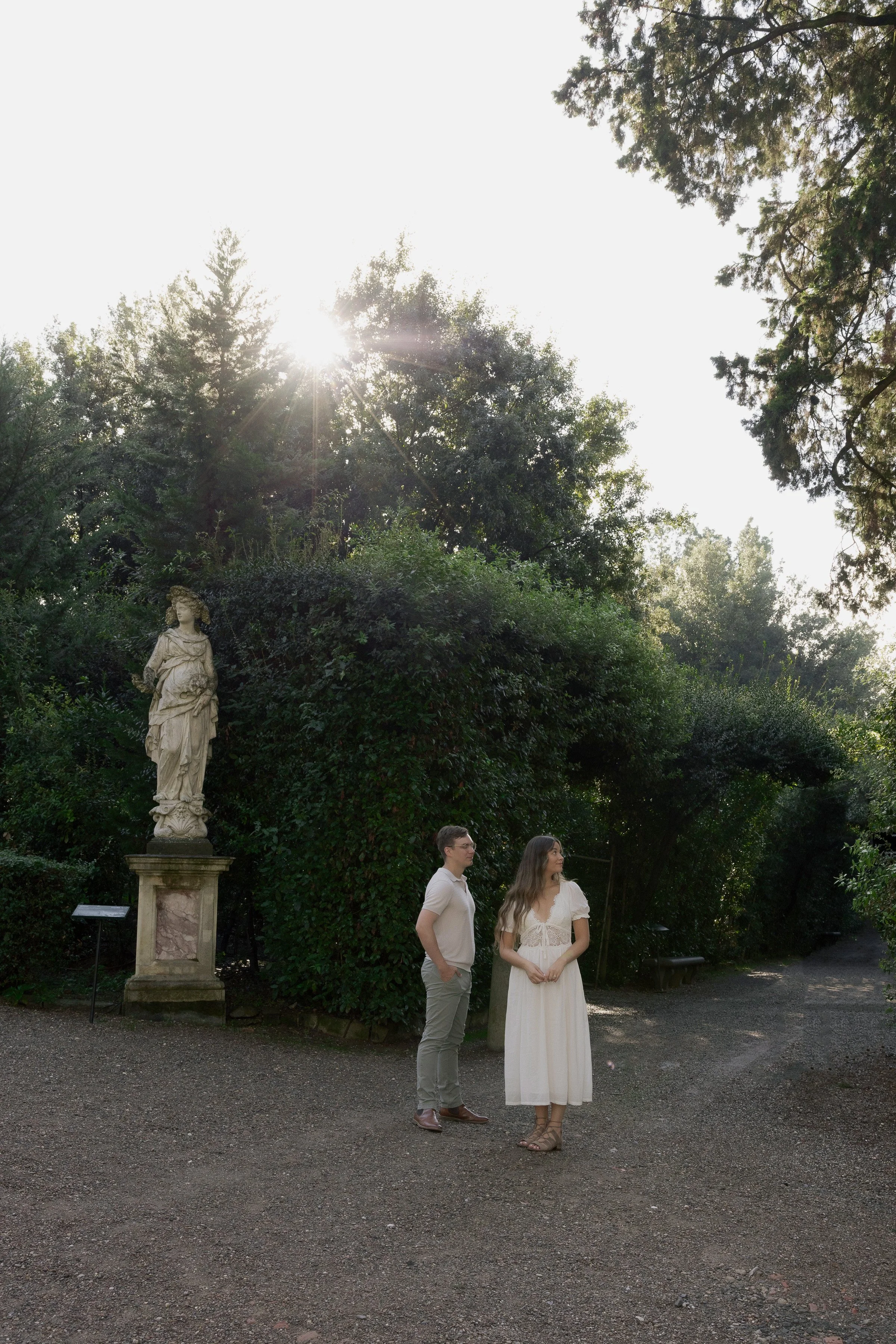 Romantic Florence couples session in an Italian garden with historic sculpture and golden sunlight