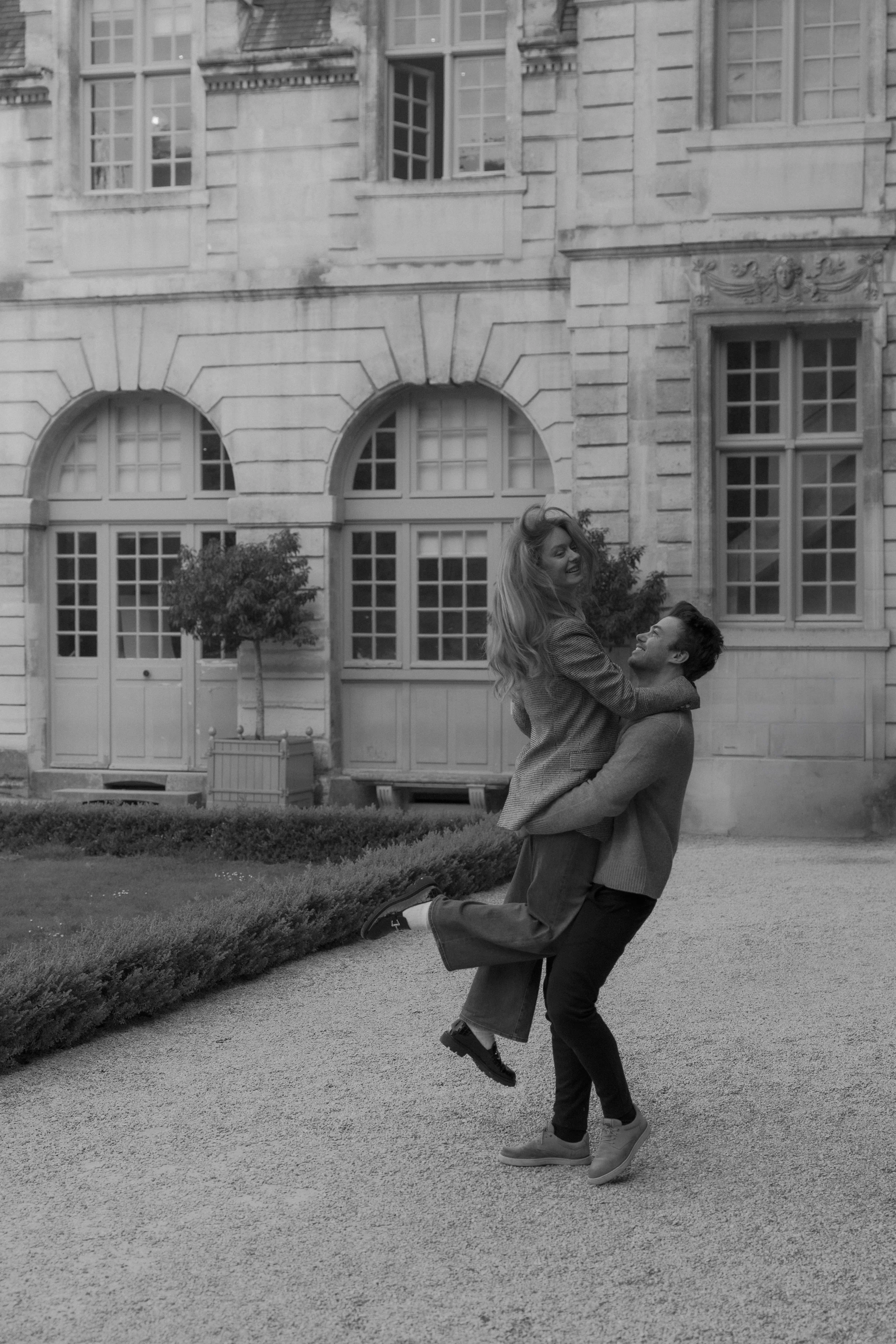 Romantic Paris couples session in front of historic French architecture at luxury destination engagement shoot