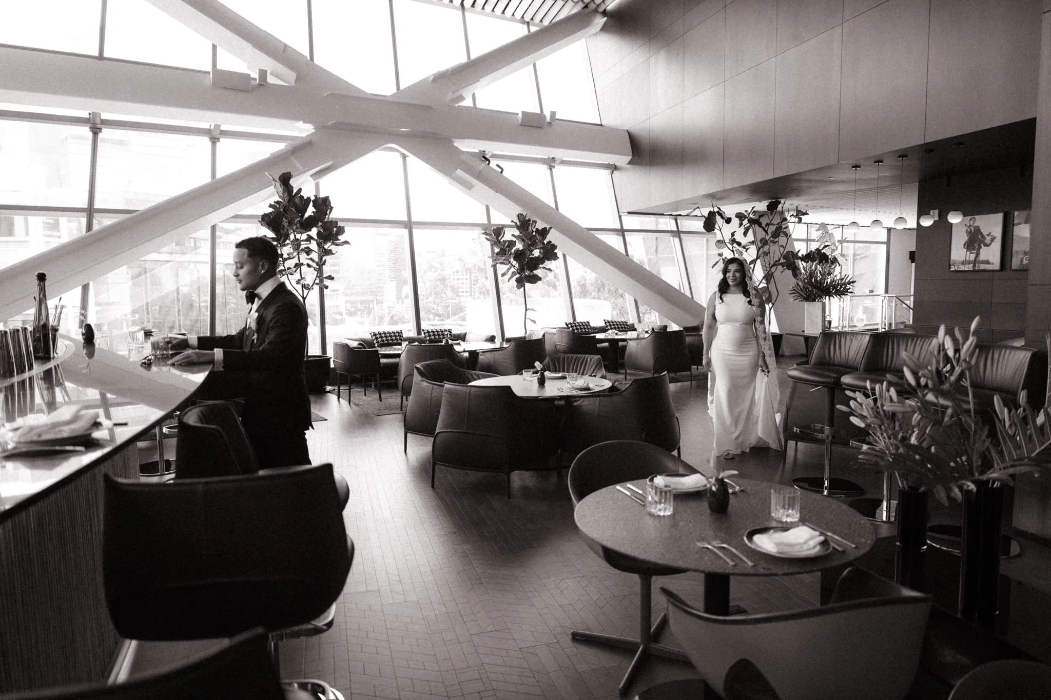 Bride and groom sharing a quiet moment inside a luxury hotel in Mexico City, surrounded by modern architecture, dramatic windows, and an elegant contemporary atmosphere.