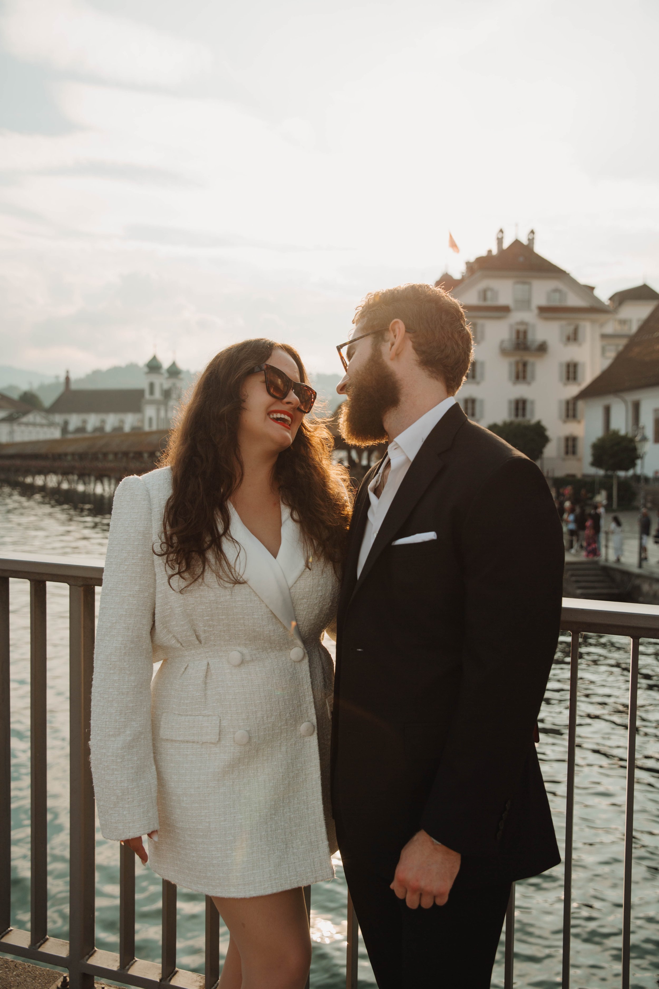 Couple laughing together by the water near the Chapel Bridge in Lucerne, Switzerland