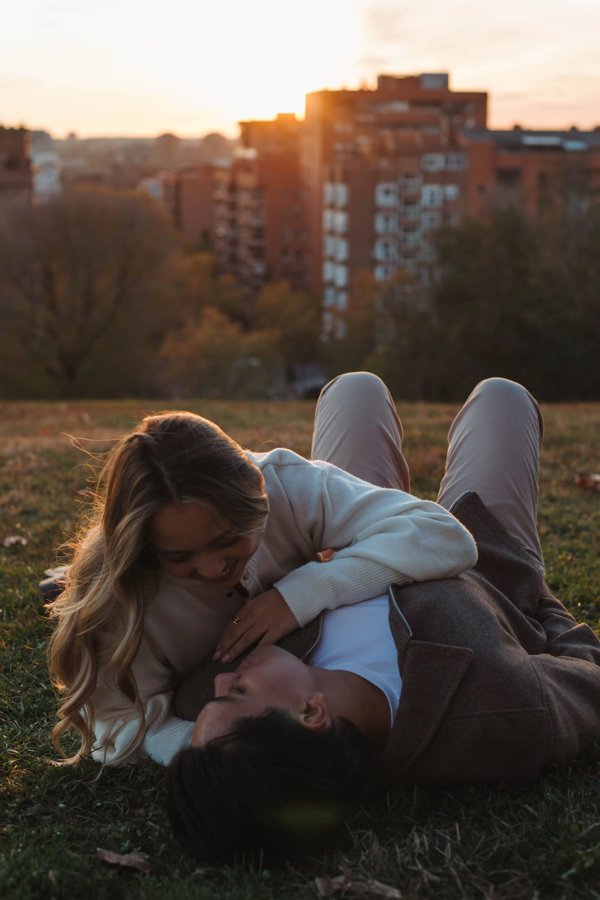 couple laying in the grass looking at each other in a park in Madrid