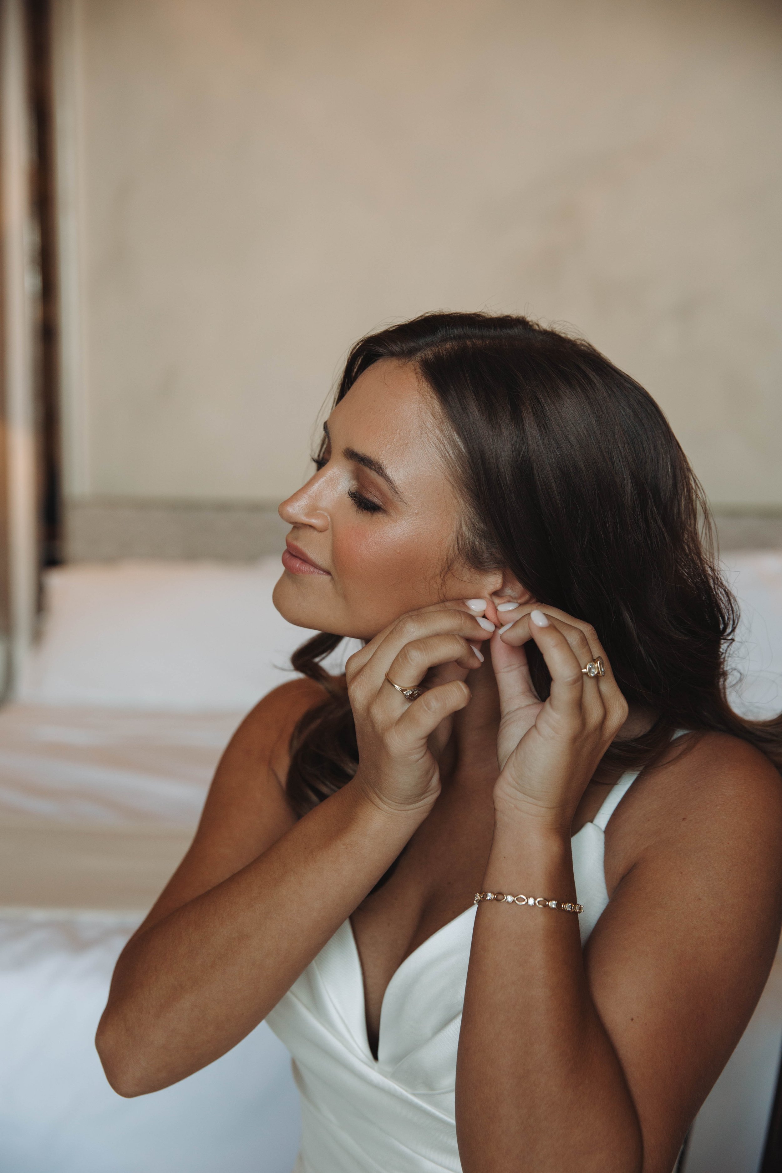 Bride putting on her earrings while getting ready at the Bellevue Syrene in Sorrento