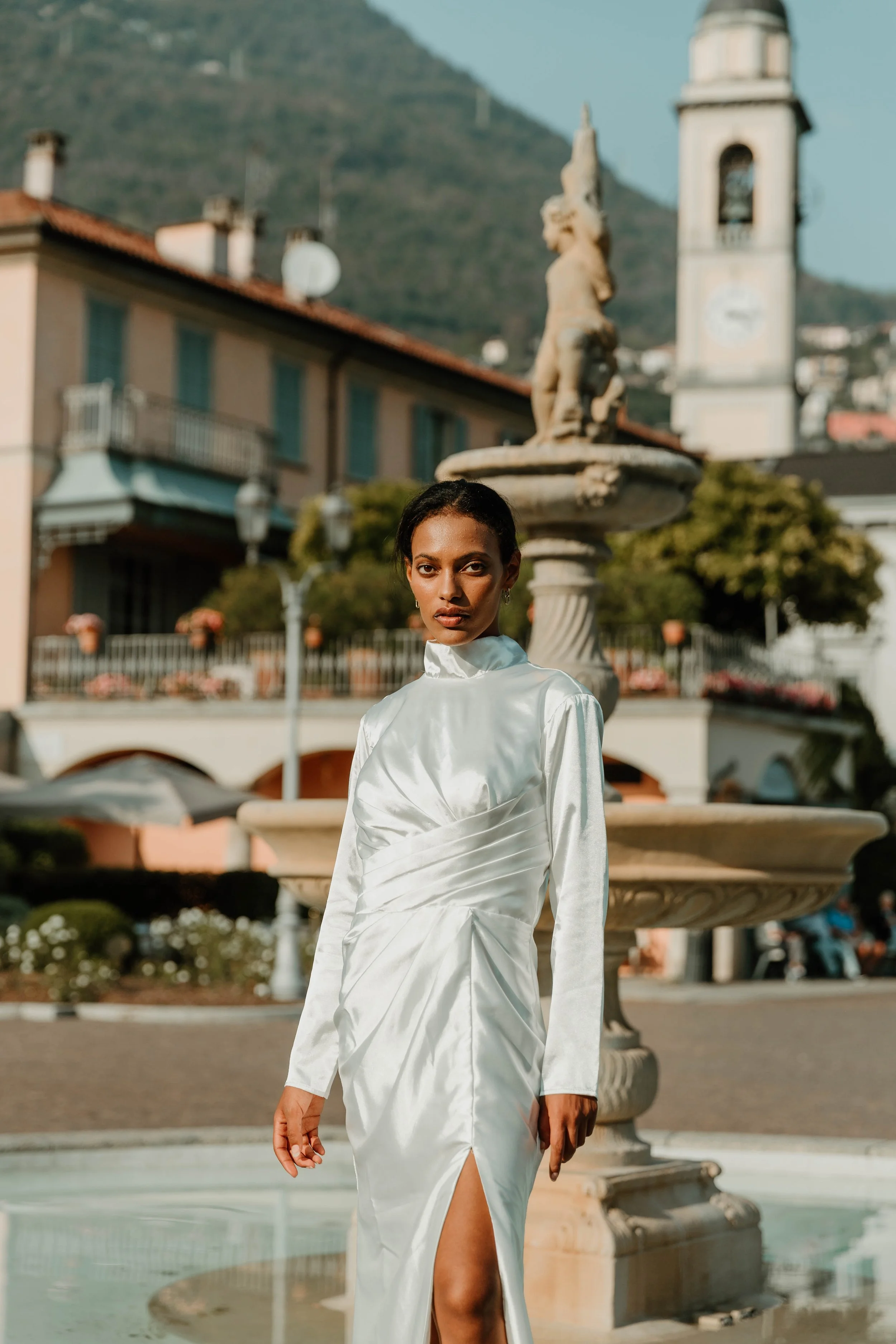 Bride in a high neck HHCo Gowns silk dress in front of the Cernobbio fountain
