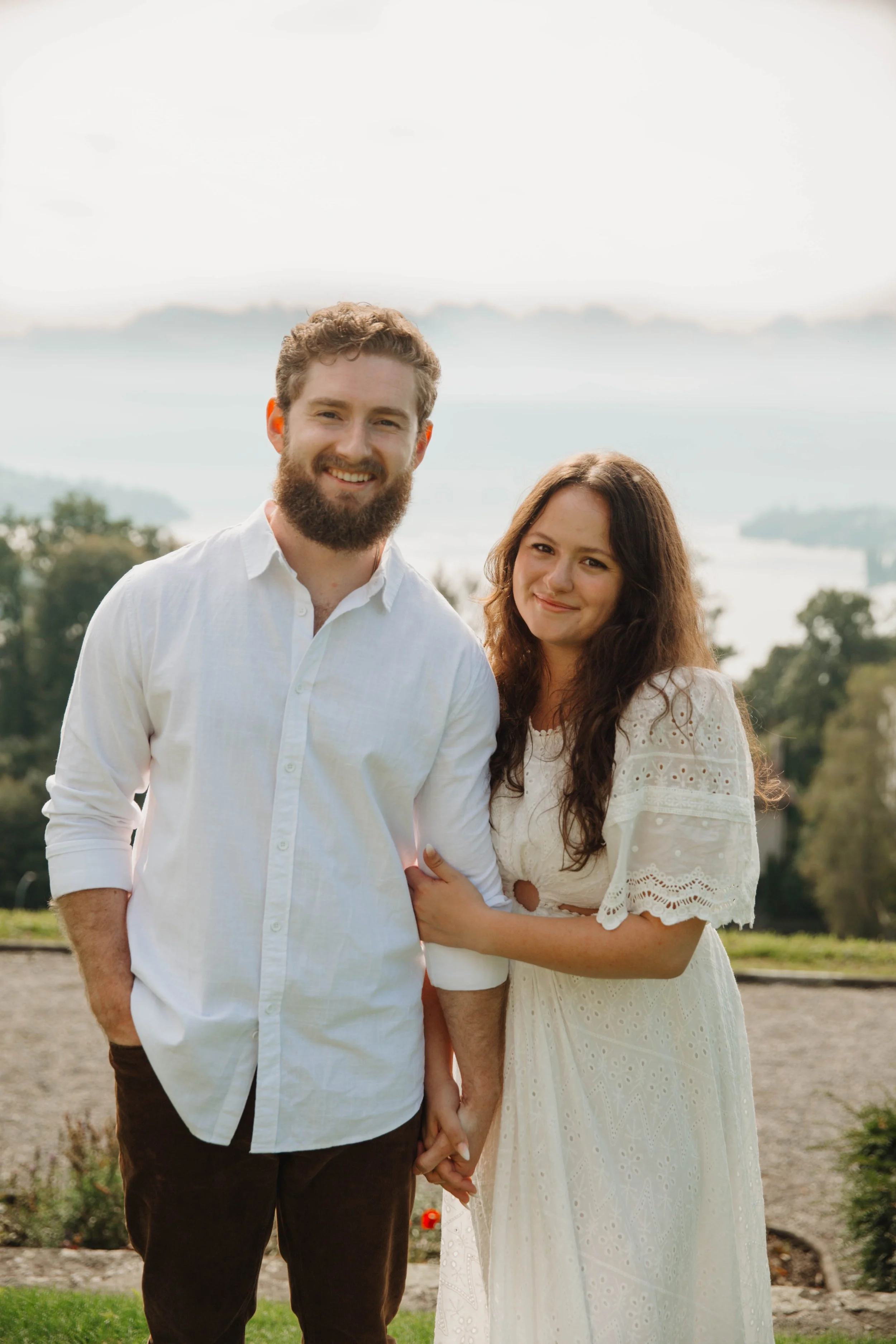 Engaged couple smiling in a hillside garden above Lake Lucerne, Switzerland
