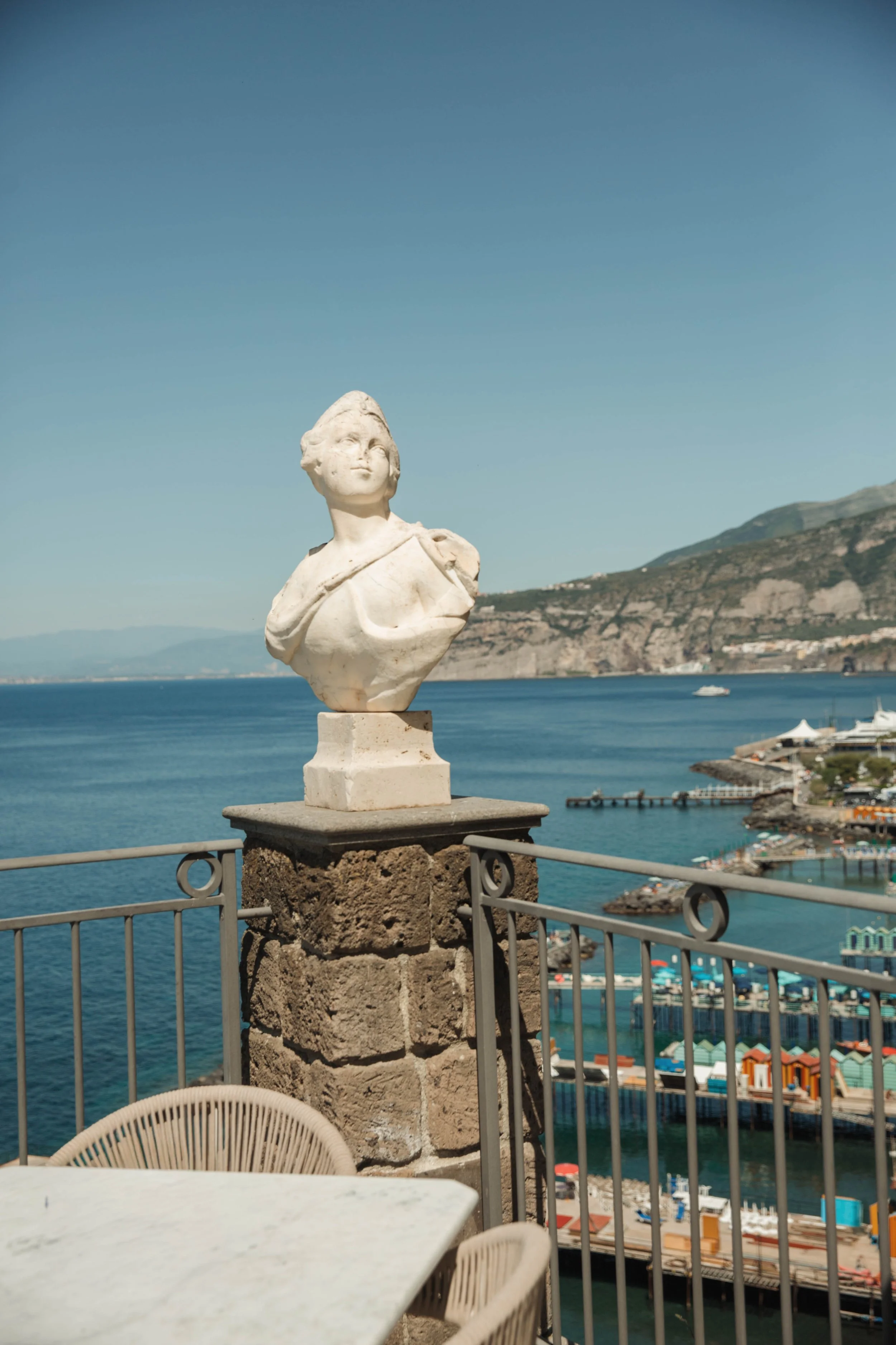 View of the Sorrento coastline and marina from the Bellevue Syrene terrace with a marble bust