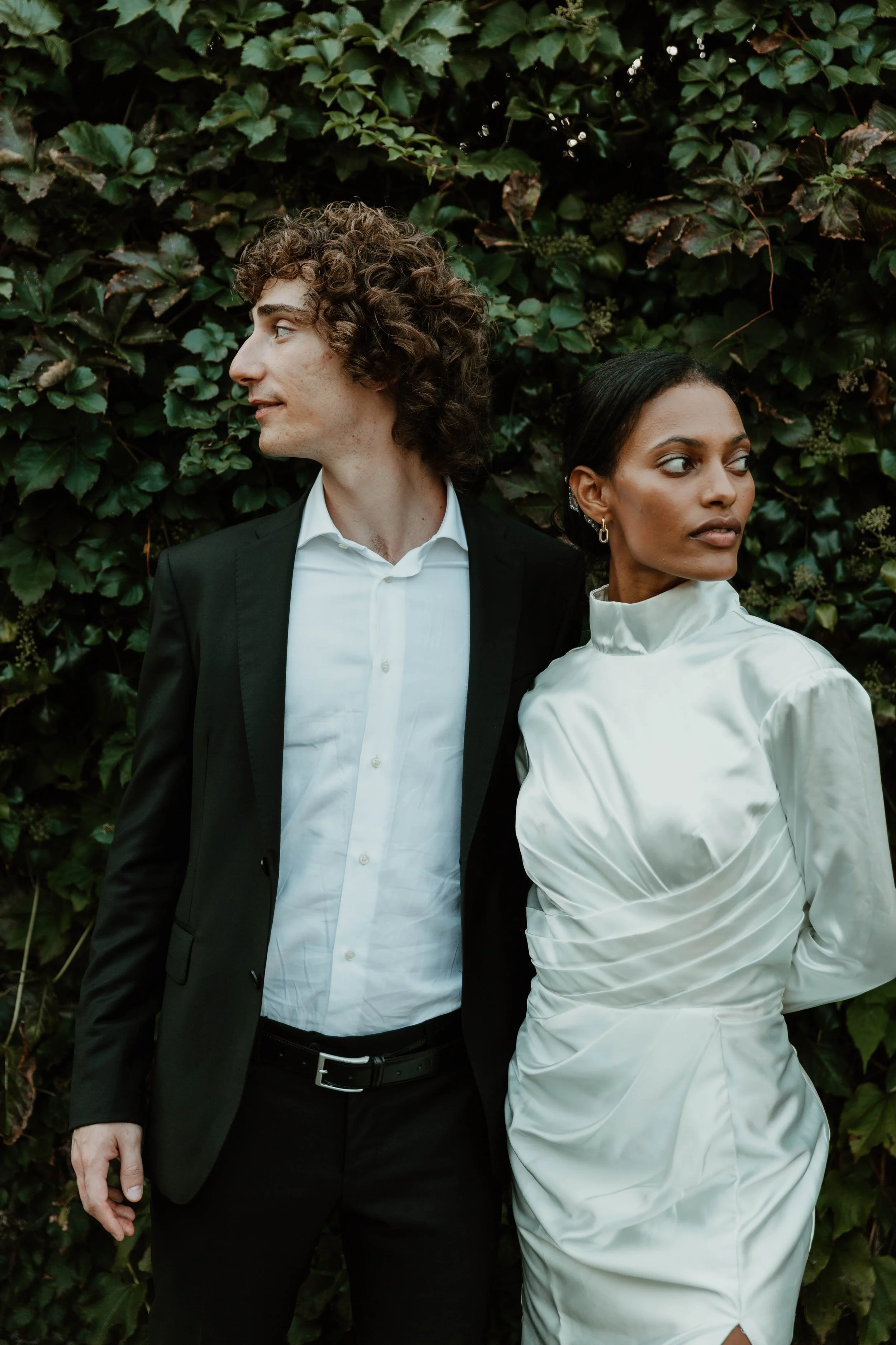 Couple standing against a green hedge during a styled wedding shoot in Cernobbio, Italy
