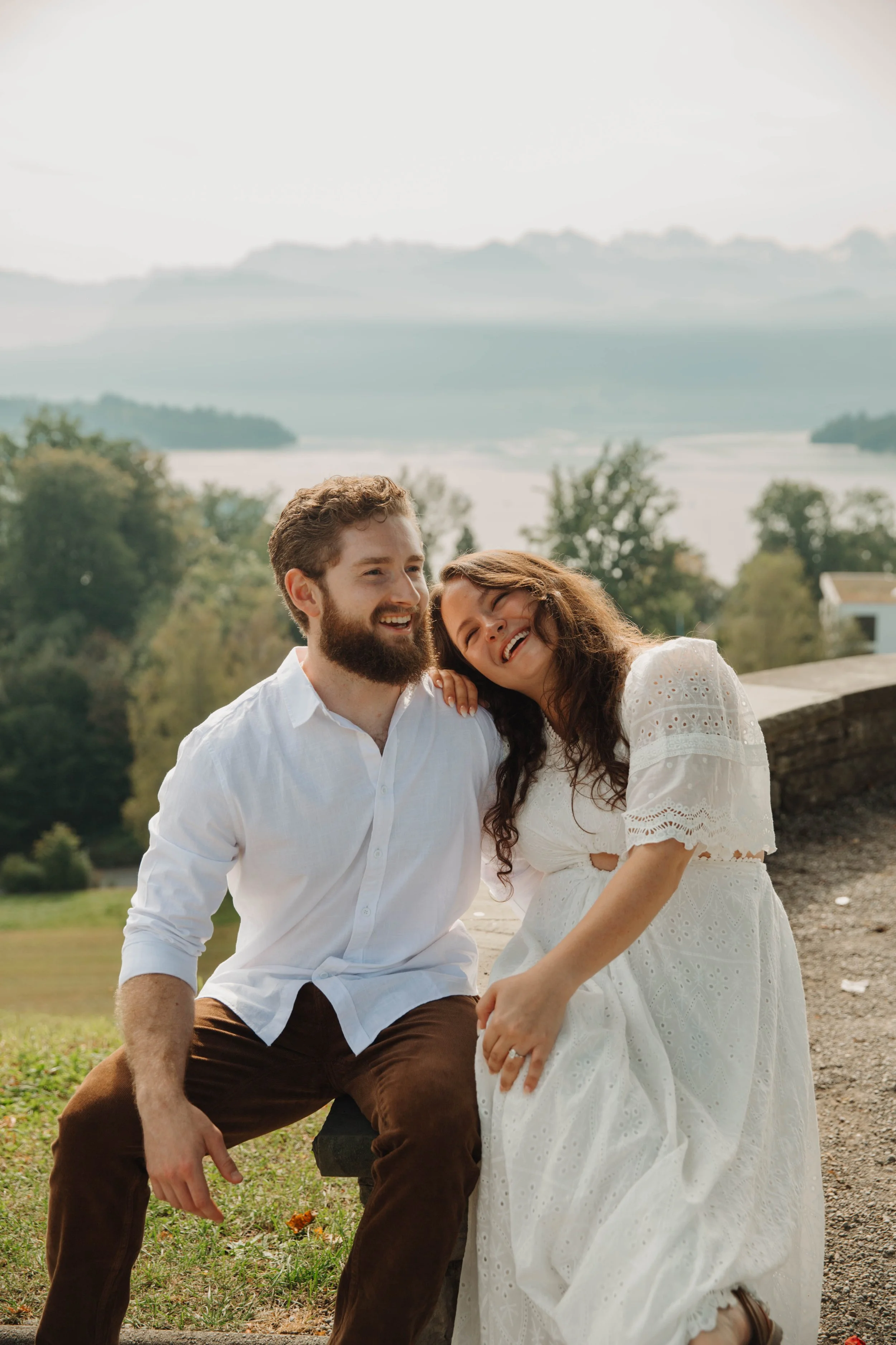 Couple sitting together on a bench above Lucerne with mountains in the distance