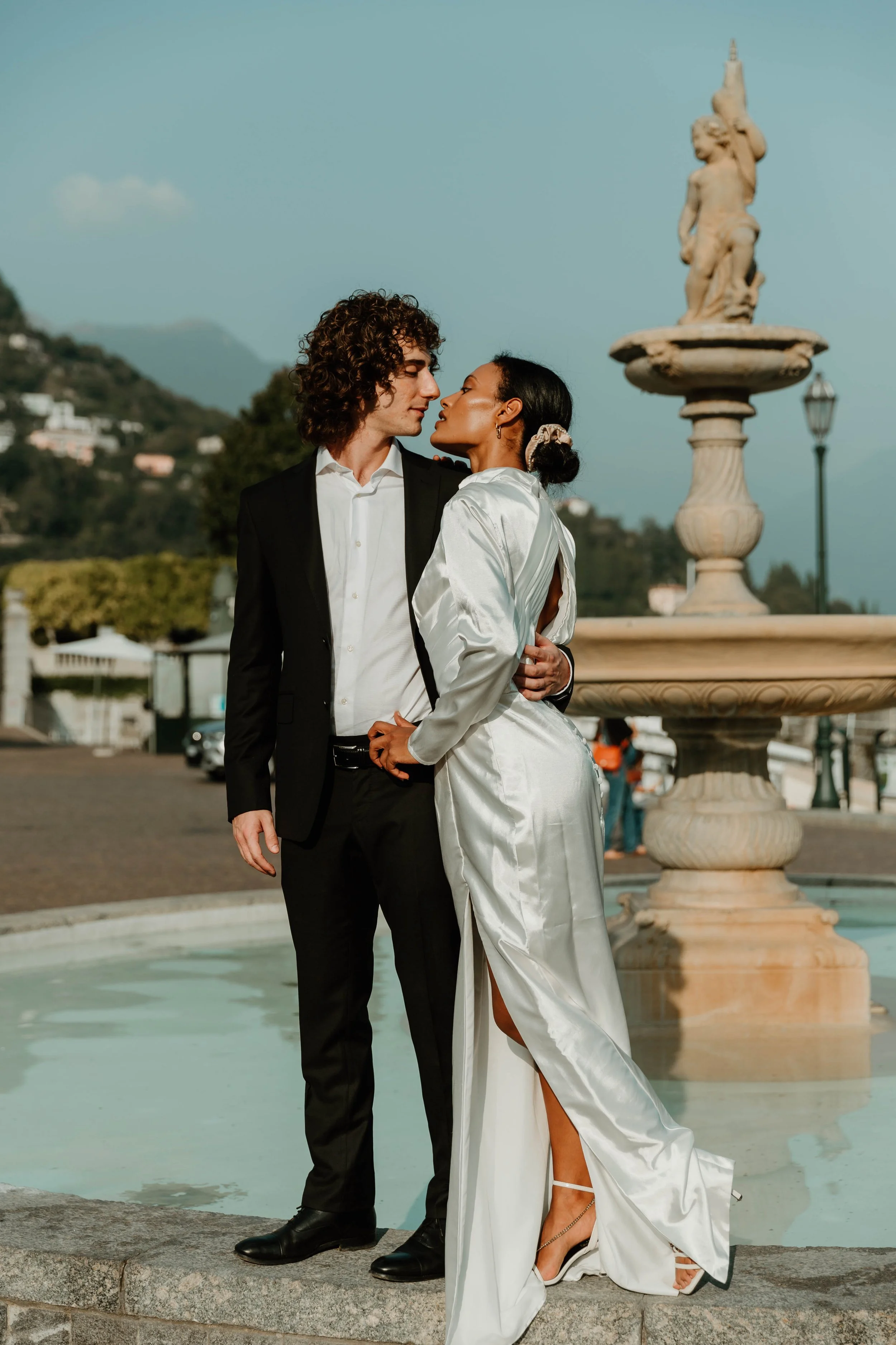 Couple embracing beside the fountain in Piazza Risorgimento, Cernobbio, on Lake Como