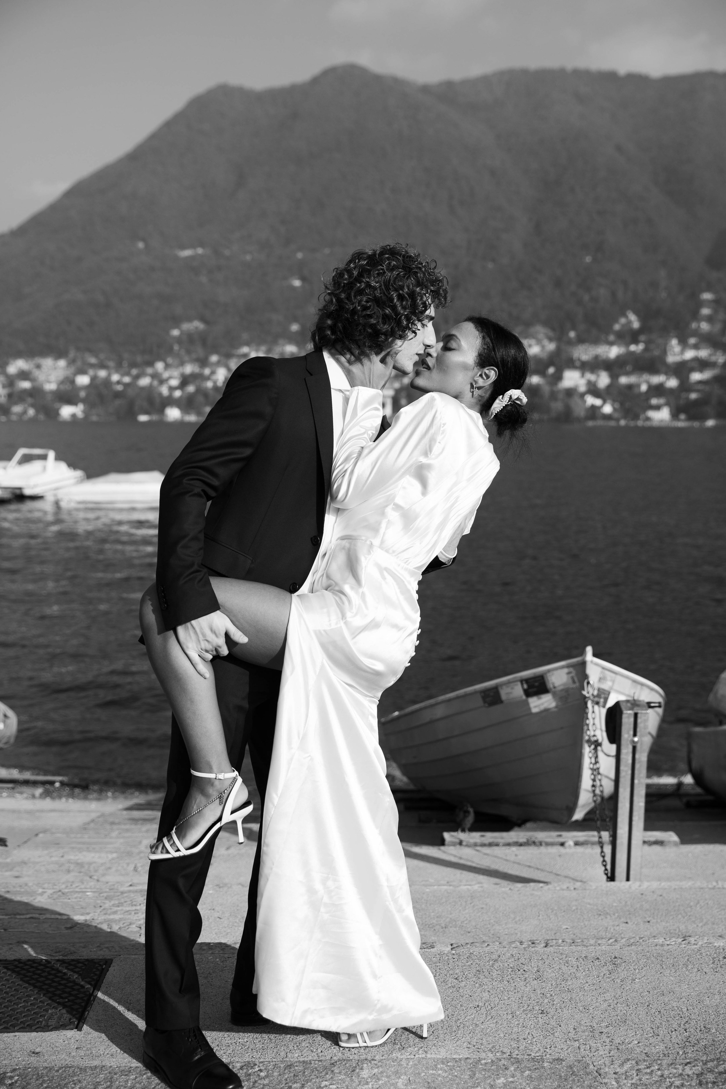 Black and white photo of a groom dipping the bride for a kiss on the Cernobbio lakefront
