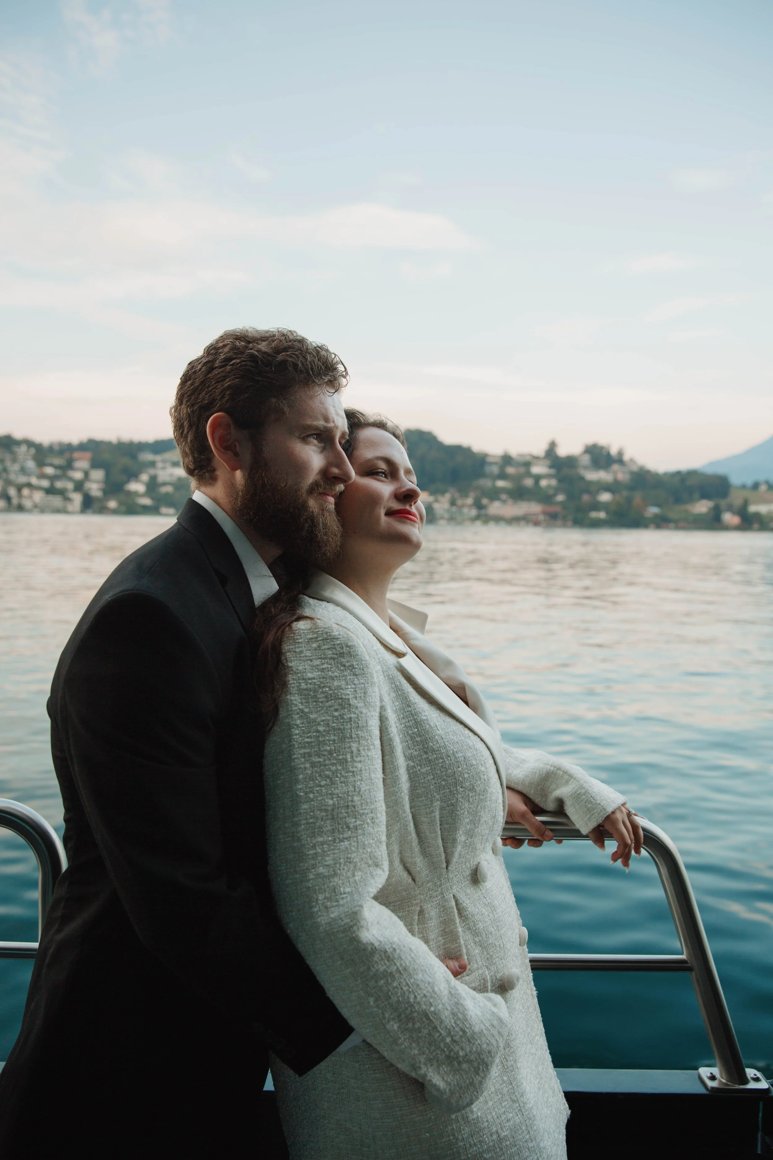 Couple embracing at the boat railing during a sunset cruise on Lake Lucerne