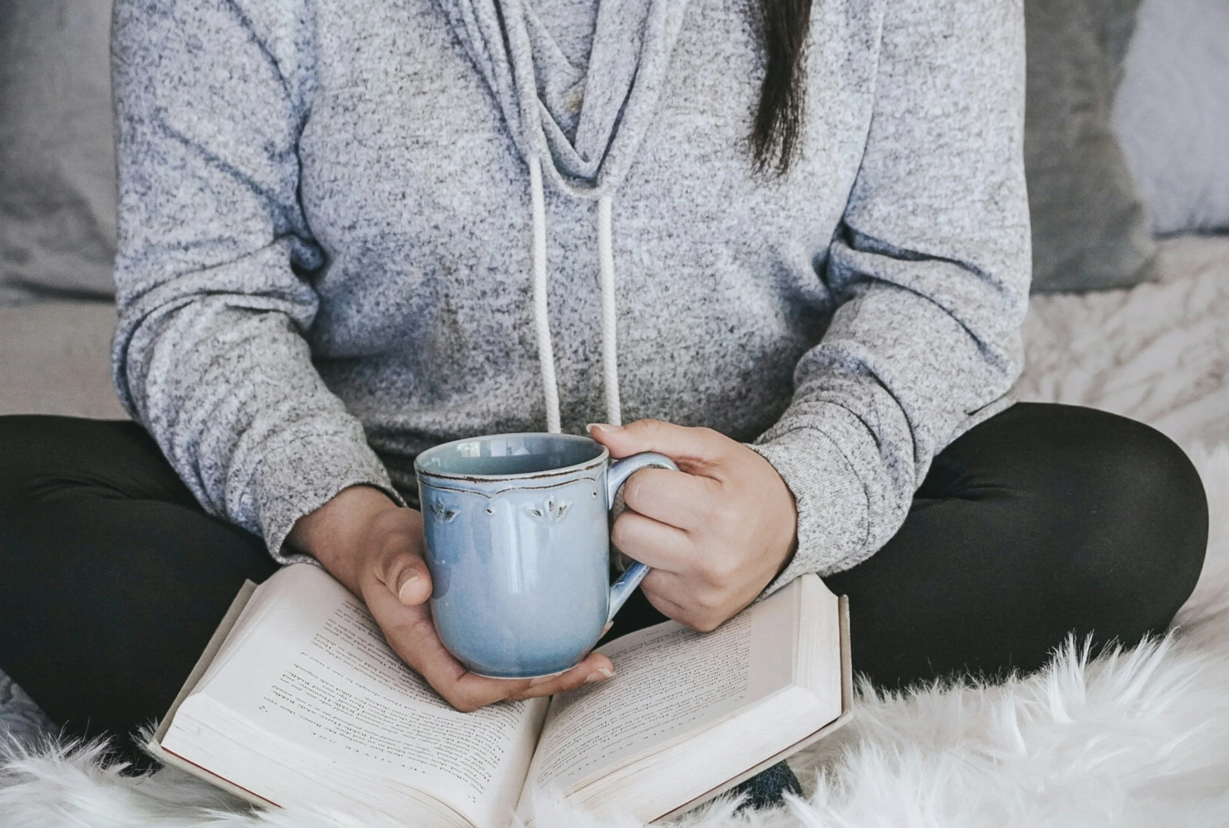 woman in gray hoodie drinking tea during online group for autistic women by Amanda Morris, LCSW