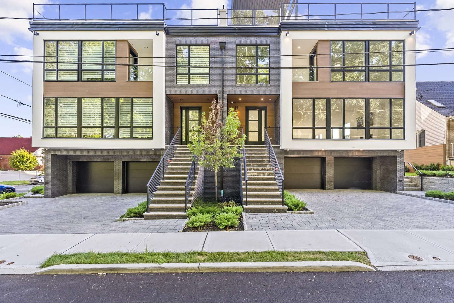 Two attached Silverline homes with wood-tone and white facades and paired entry stairs