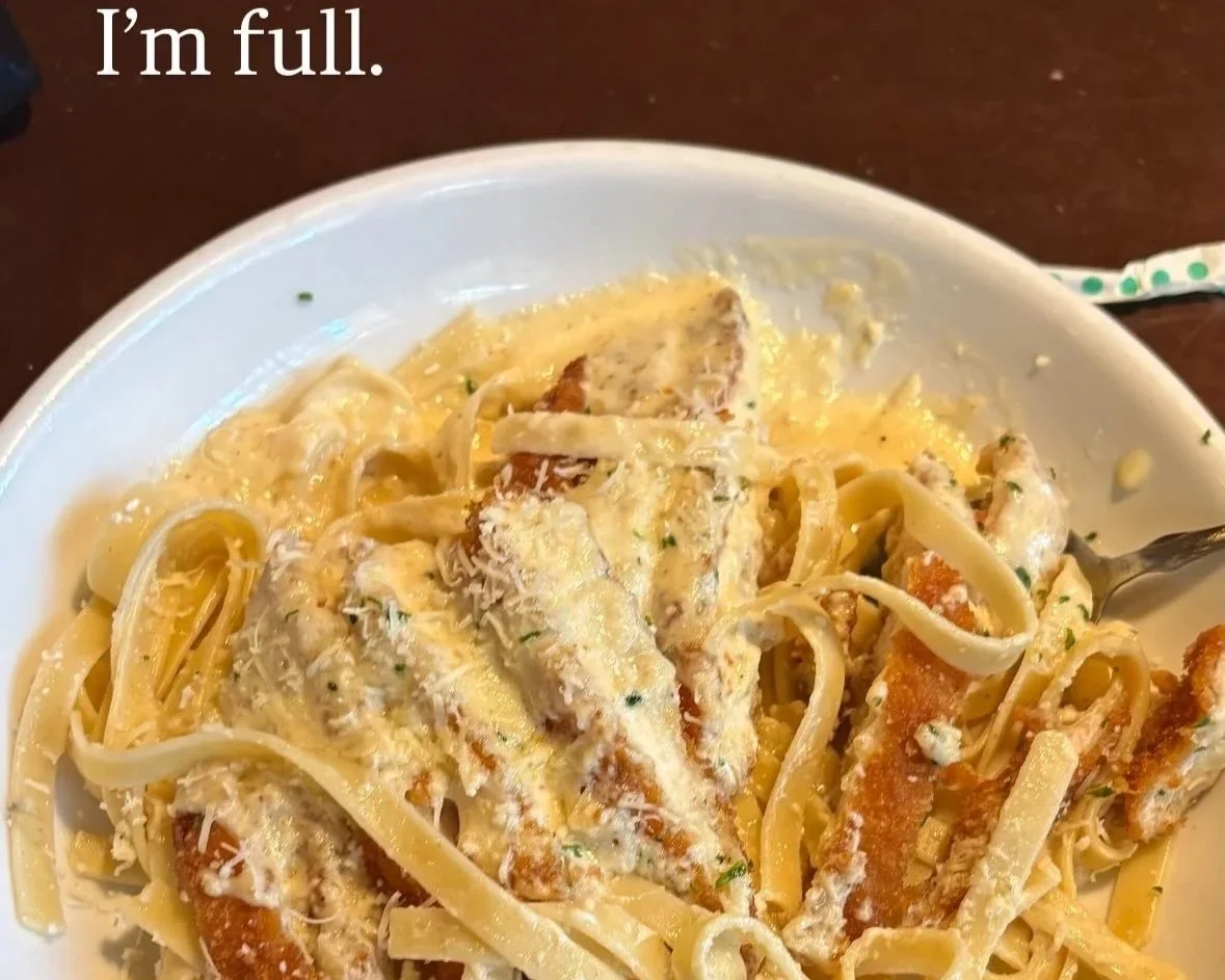 A plate of creamy pasta with chicken and grated cheese, partially eaten, with the text 'I'm full.' in the upper left corner.