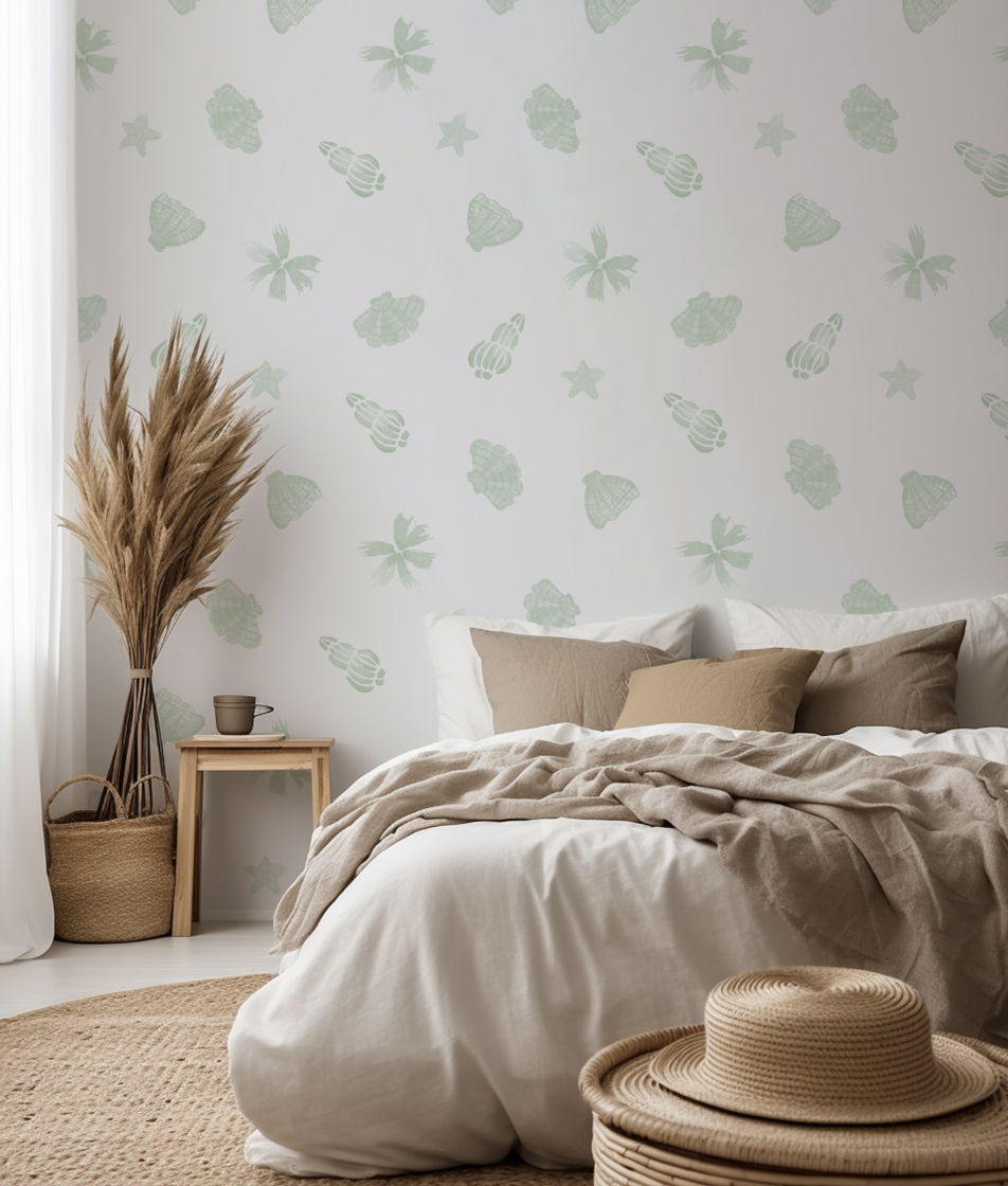 Bedroom interior featuring sage green watercolour seashell wallpaper with a soft coastal pattern. Styled with neutral bedding, woven baskets and pampas grass for a relaxed, modern coastal look
