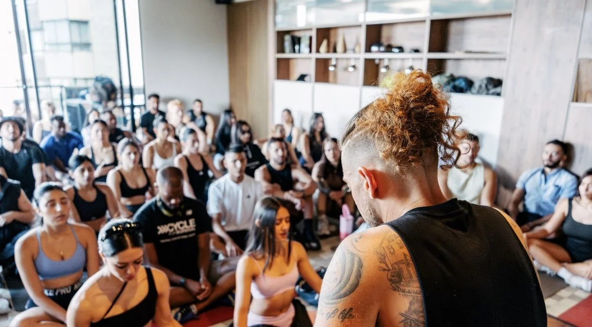 Jordan leading a wellness session with a full room in Medellín