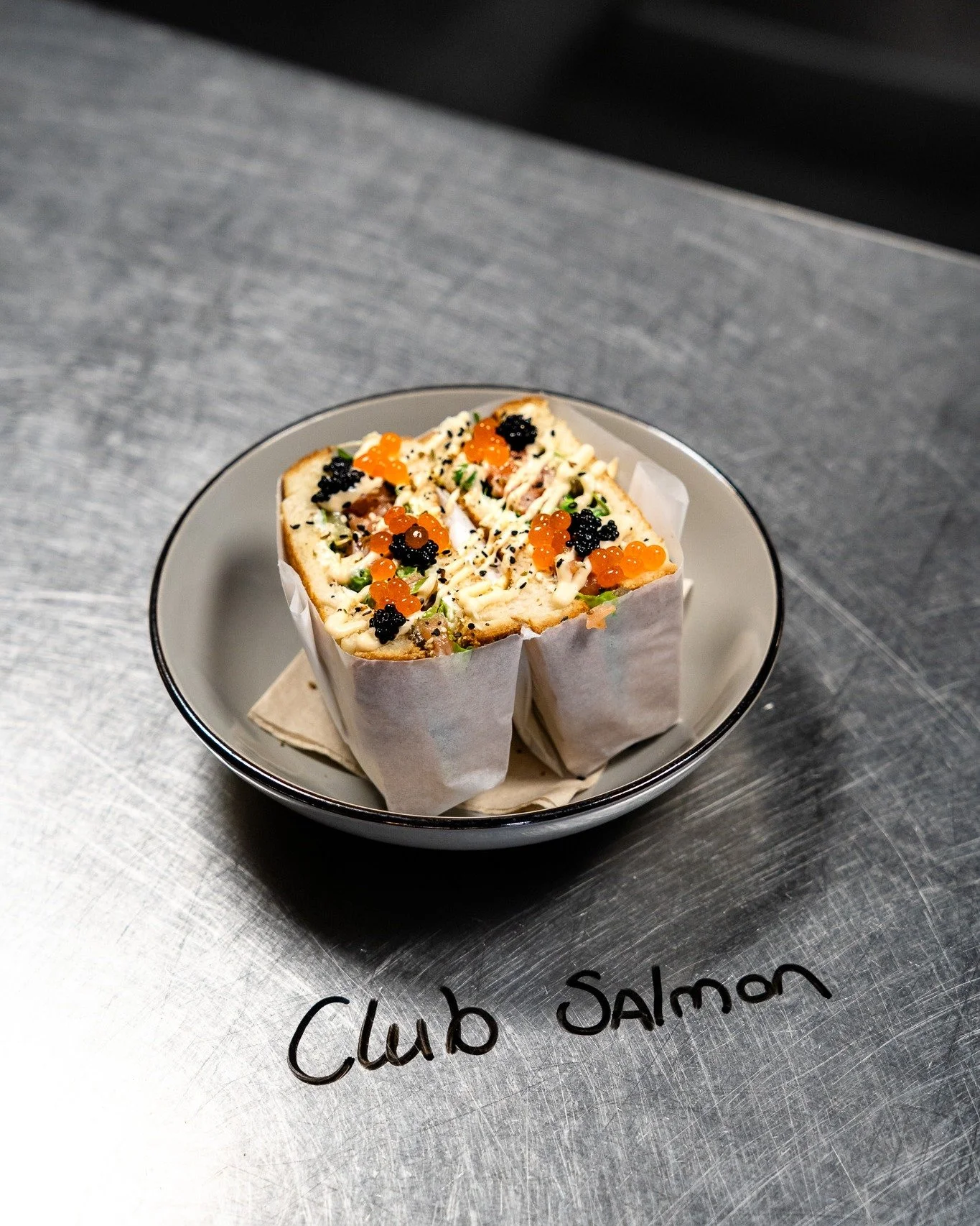 Lunch? Meet the Club Salmon. 

𝗖𝗟𝗨𝗕 𝗦𝗔𝗟𝗠𝗢𝗡 𝗦𝗔𝗡𝗗𝗪𝗜𝗖𝗛
Zalmtartaar, cream cheese, bagel seasoning, thousand island dressing, romaine sla, doperwtjes, augurk, faux zeewier kaviaar, zachte brioche 

Elke vrijdag, zaterdag en zondag vanaf