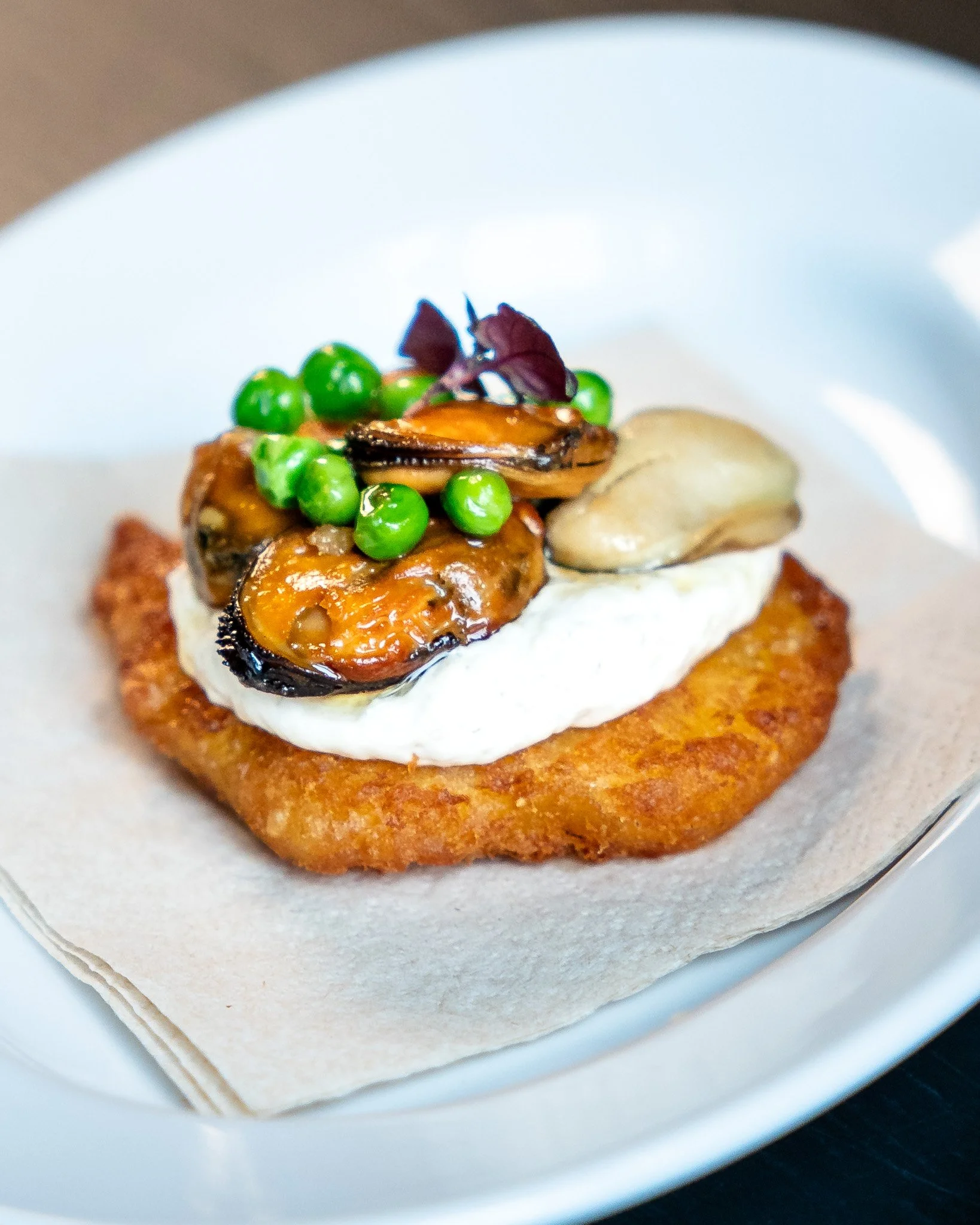 Heerlijke bite bij onze All Day IPA of Tripel D'or: 𝗛𝗔𝗬 𝗦𝗠𝗢𝗞𝗘𝗗 𝗠𝗨𝗦𝗦𝗘𝗟 𝗛𝗔𝗦𝗛𝗕𝗥𝗢𝗪𝗡
Aardappel krokant, mosselen in brown butter, langoustine bisque mayo, doperwtjes