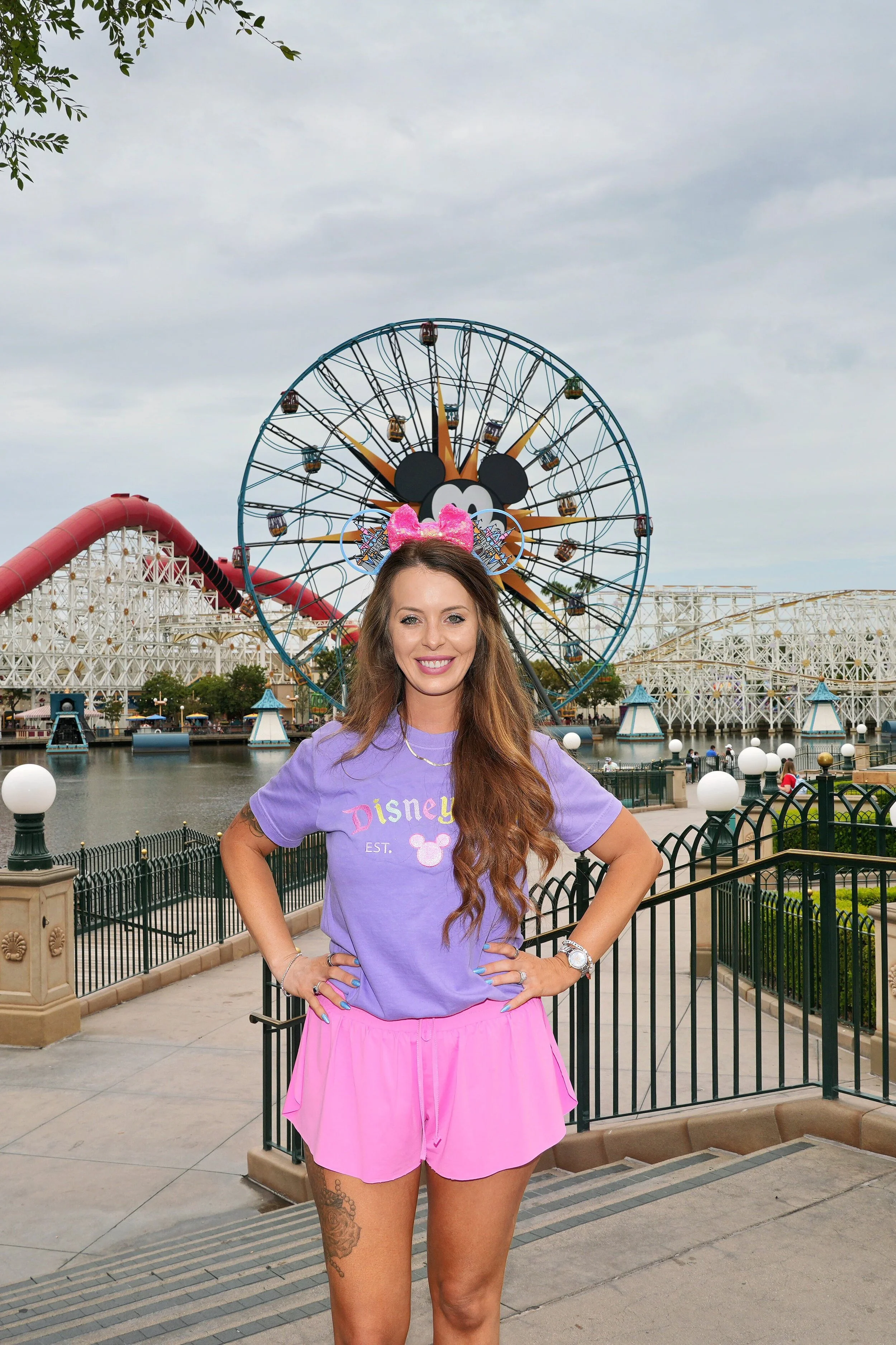 Allie Lahmers, Travel Advisor, smiling at Disney California Adventure with the Pixar Pal-A-Round behind her.
