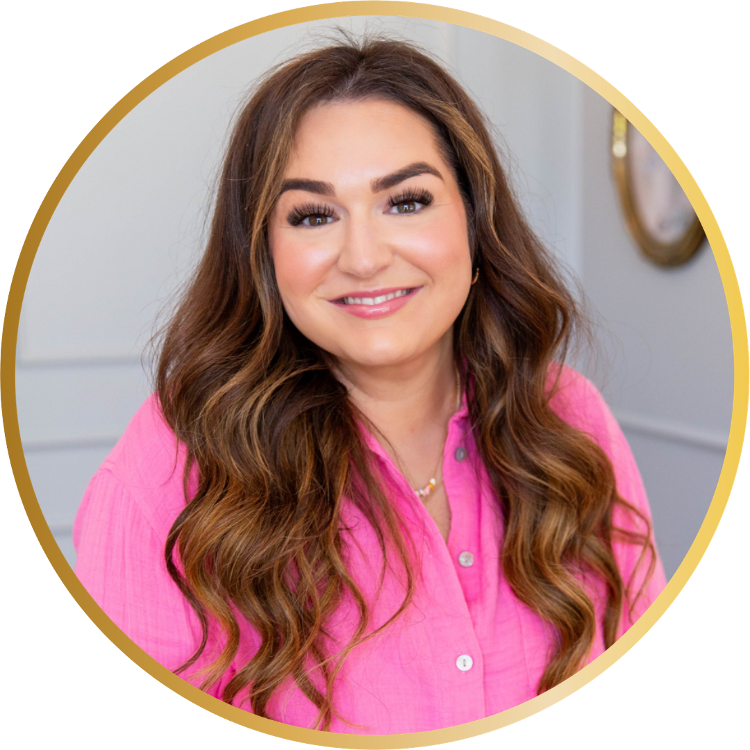 Professional headshot of a smiling woman with long wavy brown hair, wearing a bright pink blouse, photographed against a soft neutral background.