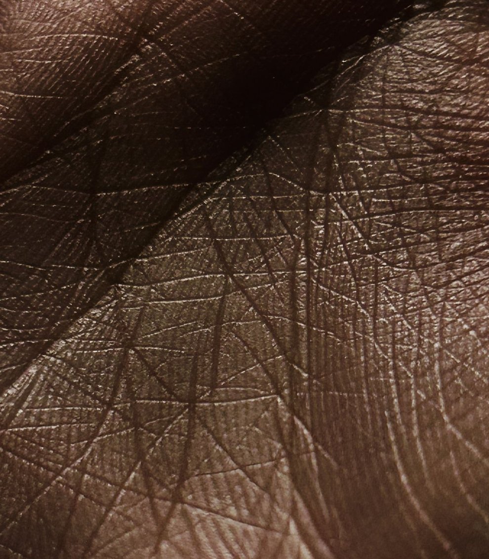 Close-up of a brown leather surface with visible grain and fine scratches.
