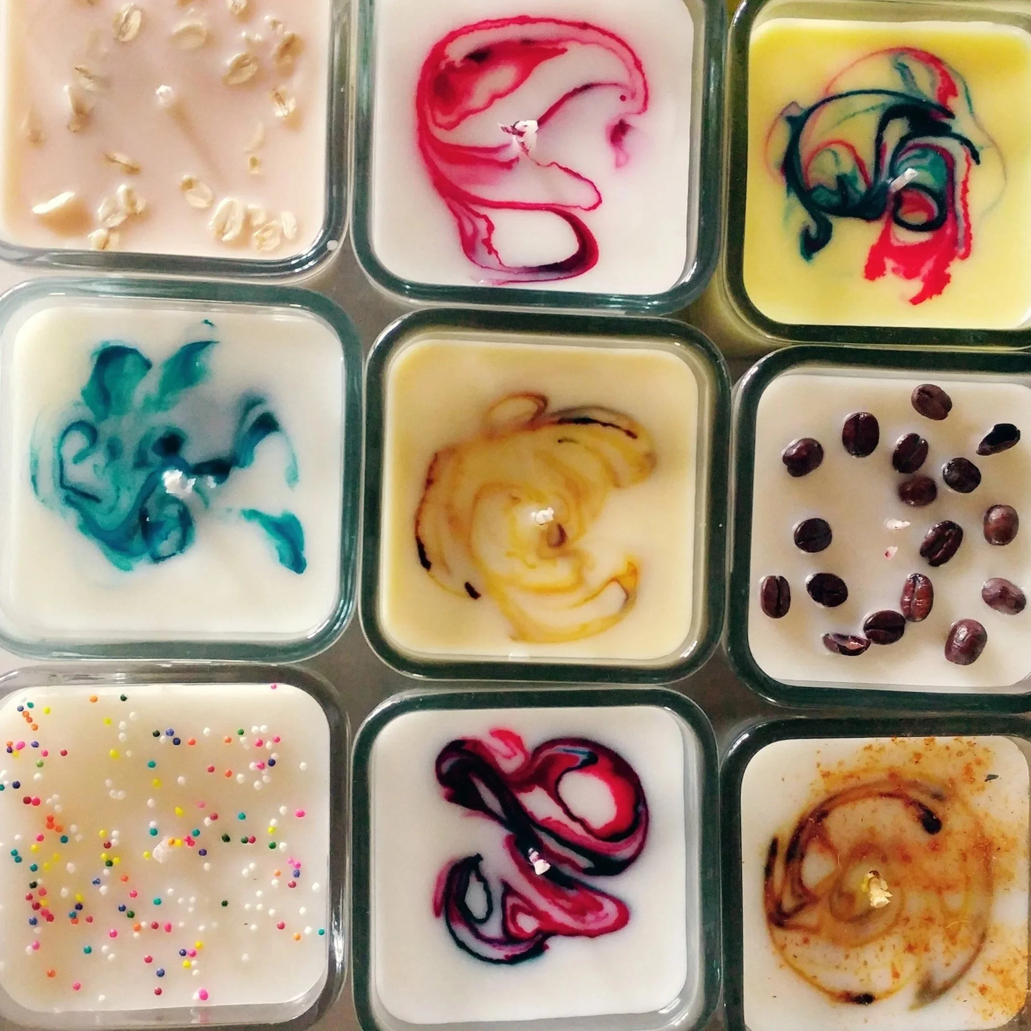 Various containers of colorful ice cream with different swirl patterns, sprinkles, and toppings.
