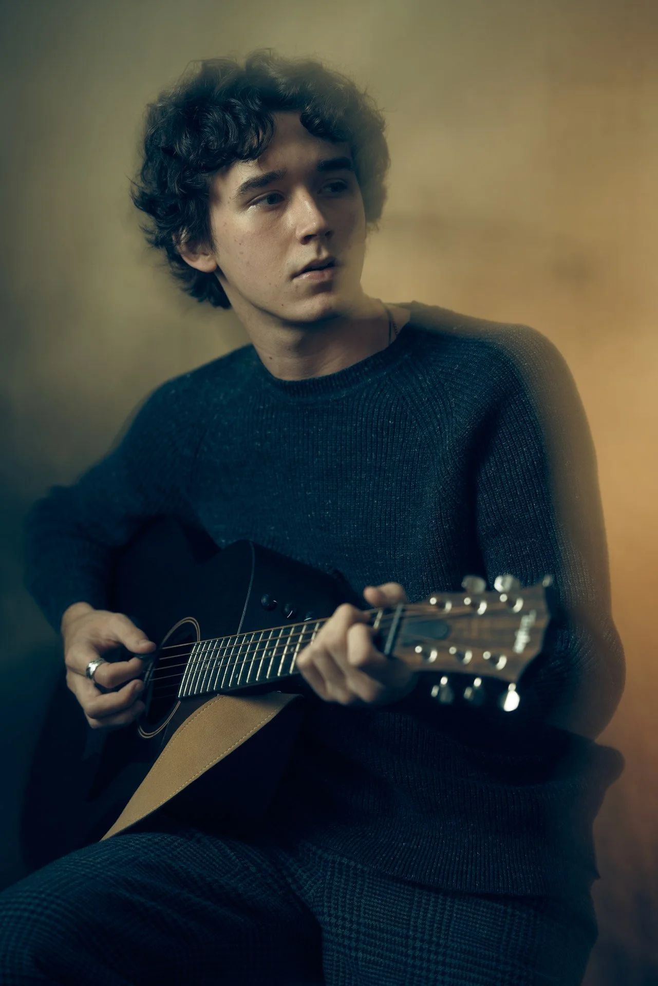 High school senior playing guitar during a studio senior portrait session in Nashville