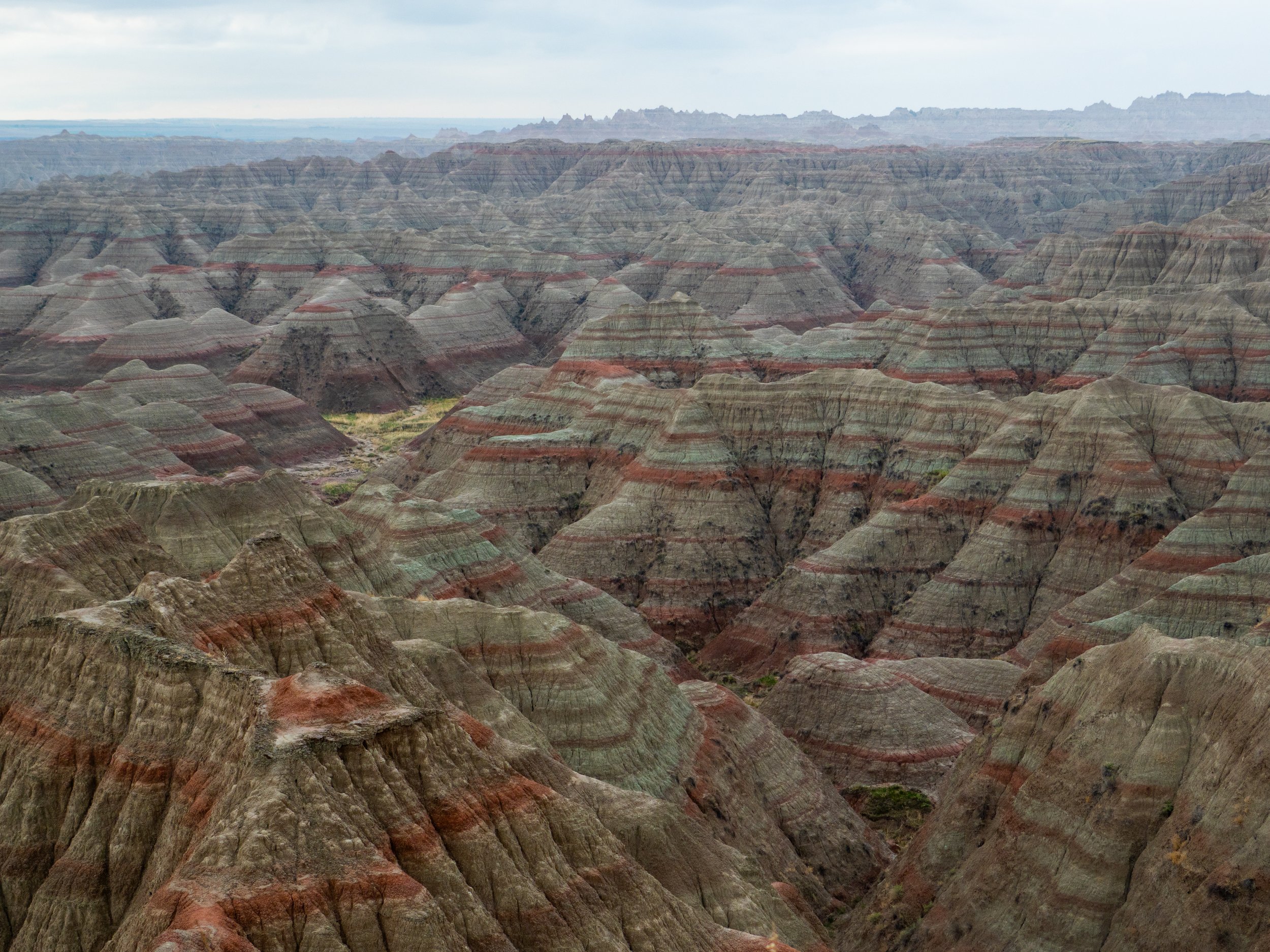 View of the Grand Canyon with layered rock formations and a cloudy sky