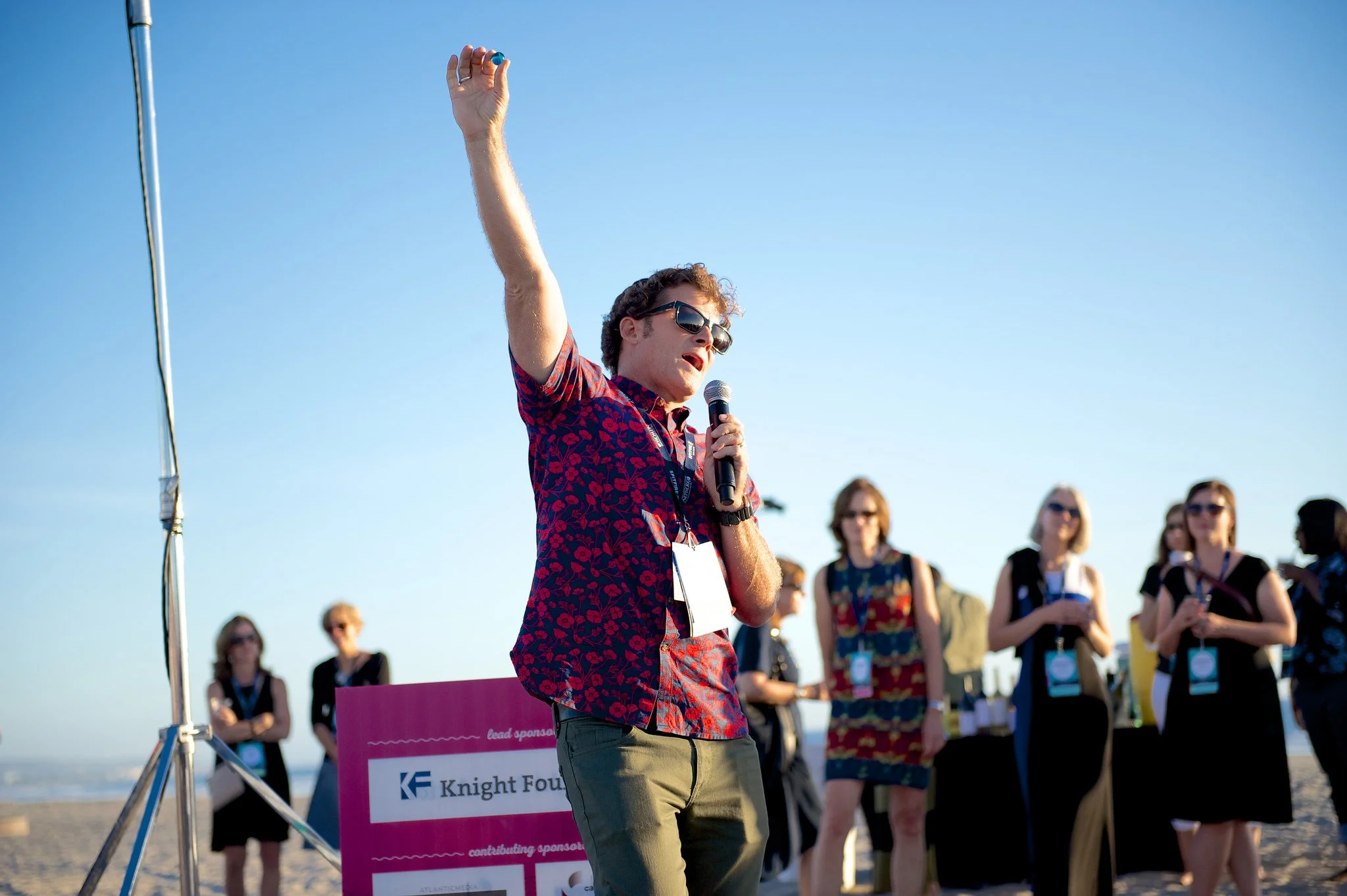 A man giving a speech outside in front of a crowd.