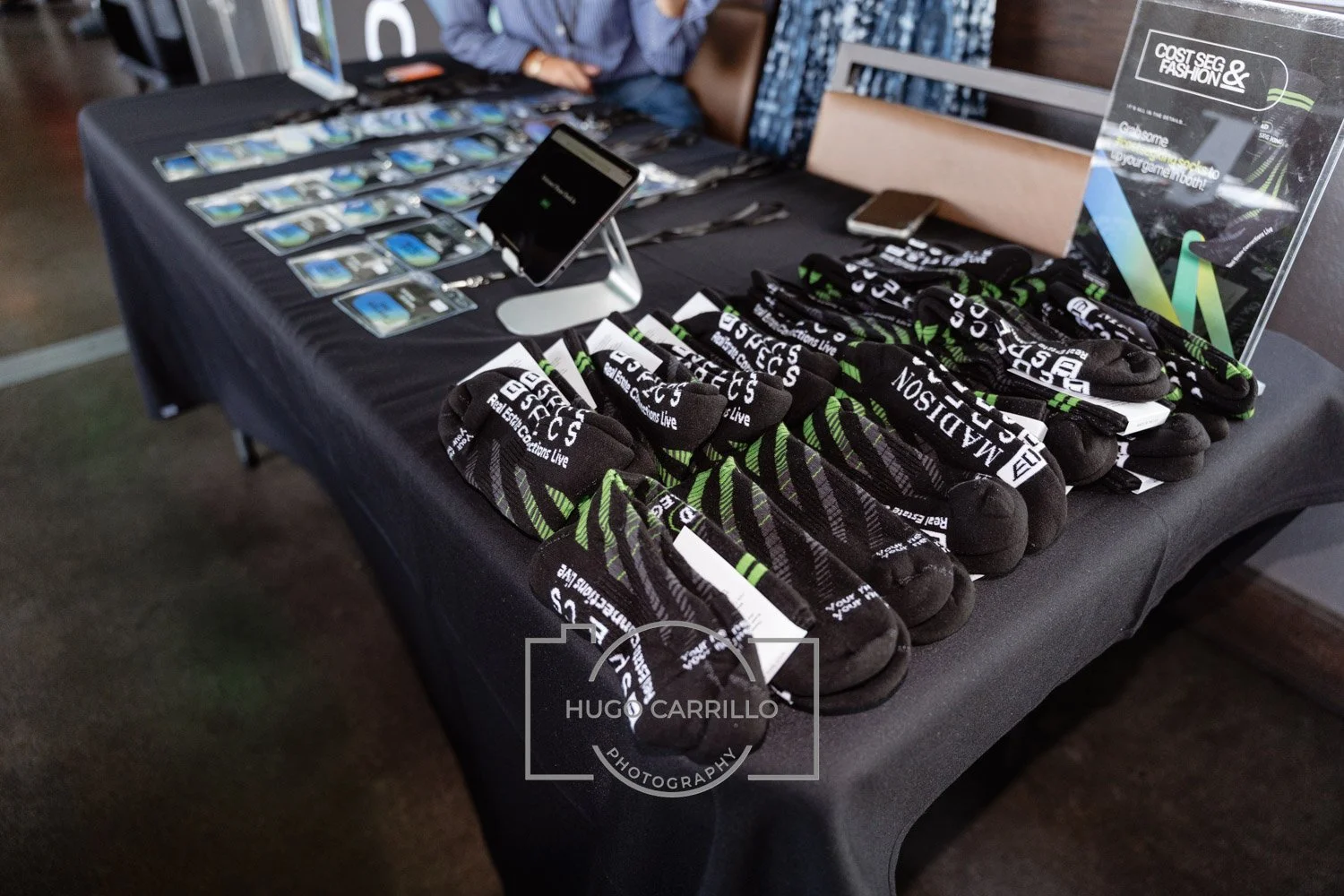 Display table with socks, mobile phones, and promotional materials for a conference or event.