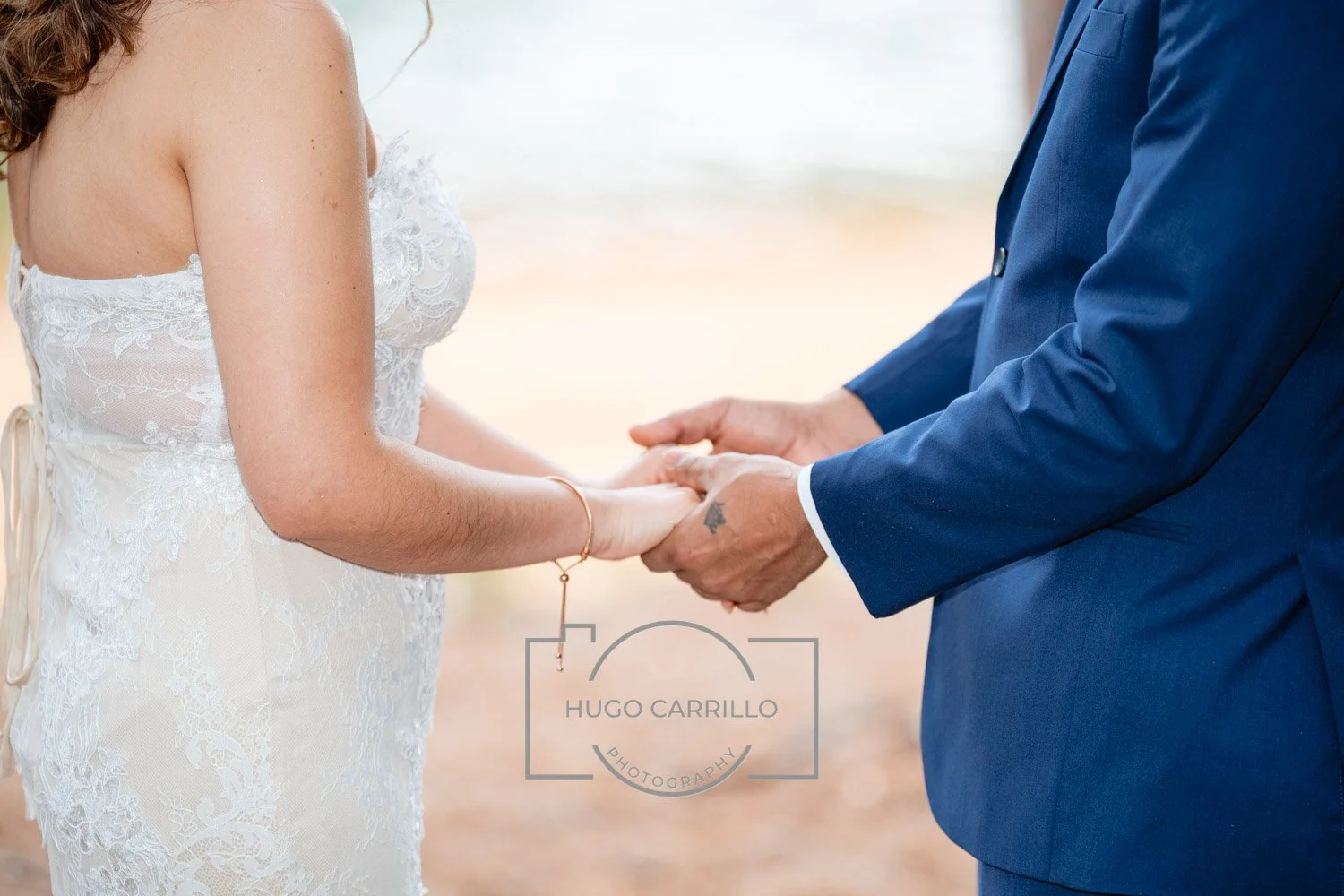 A bride and groom holding hands during their wedding ceremony.