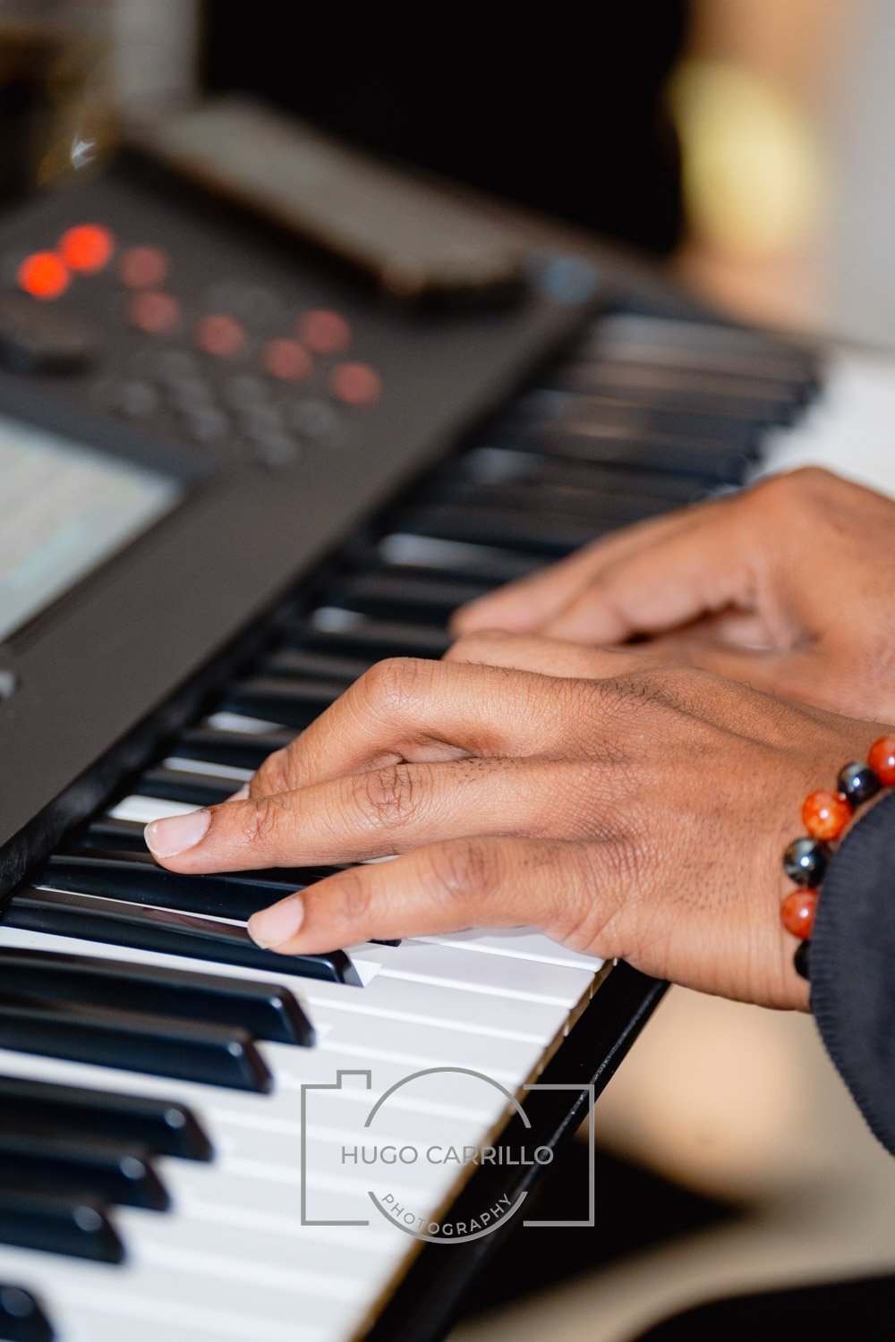 Close-up of a person's hands playing the keys of a digital piano or keyboard.