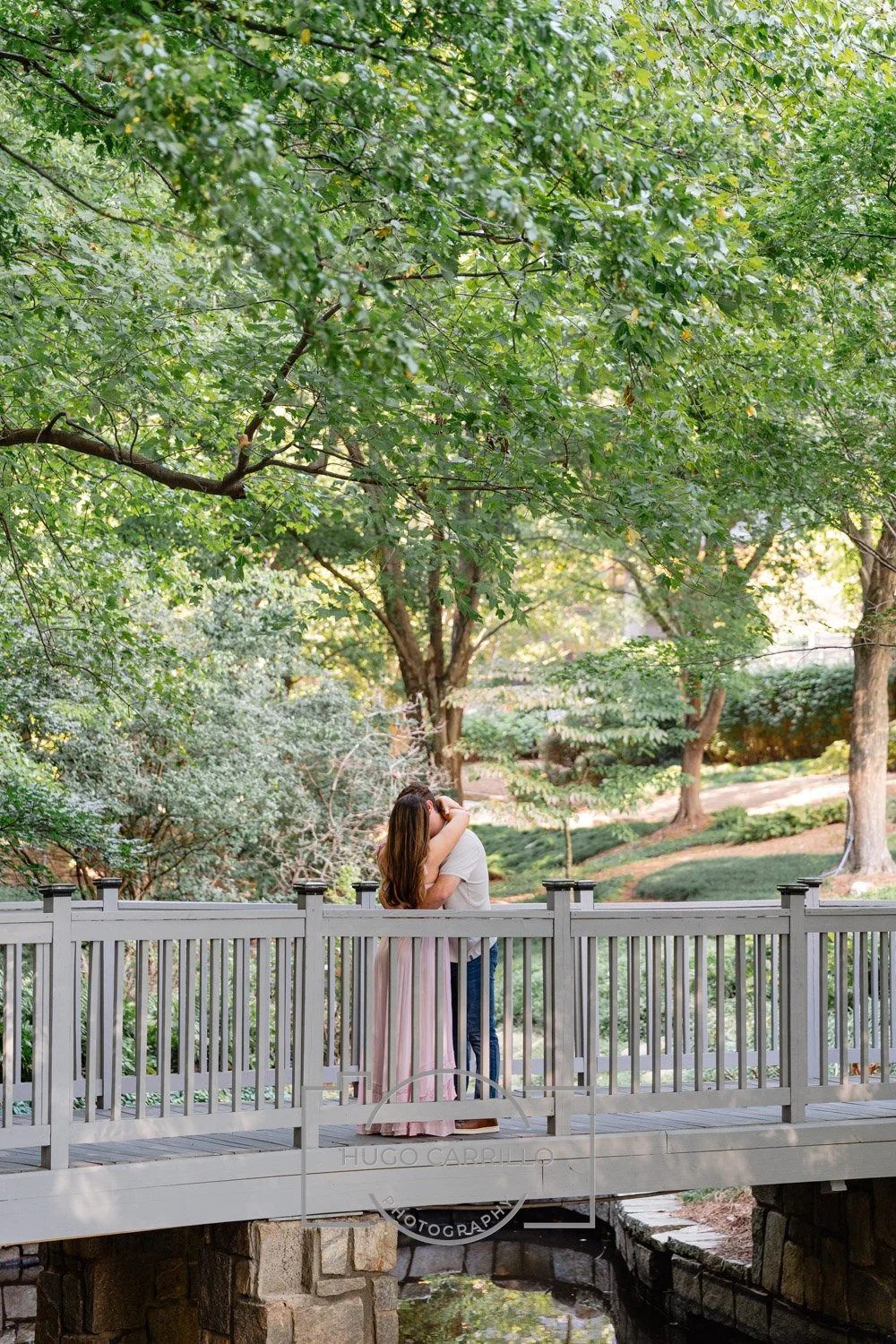 A newly engaged couple embraces on the bridge
