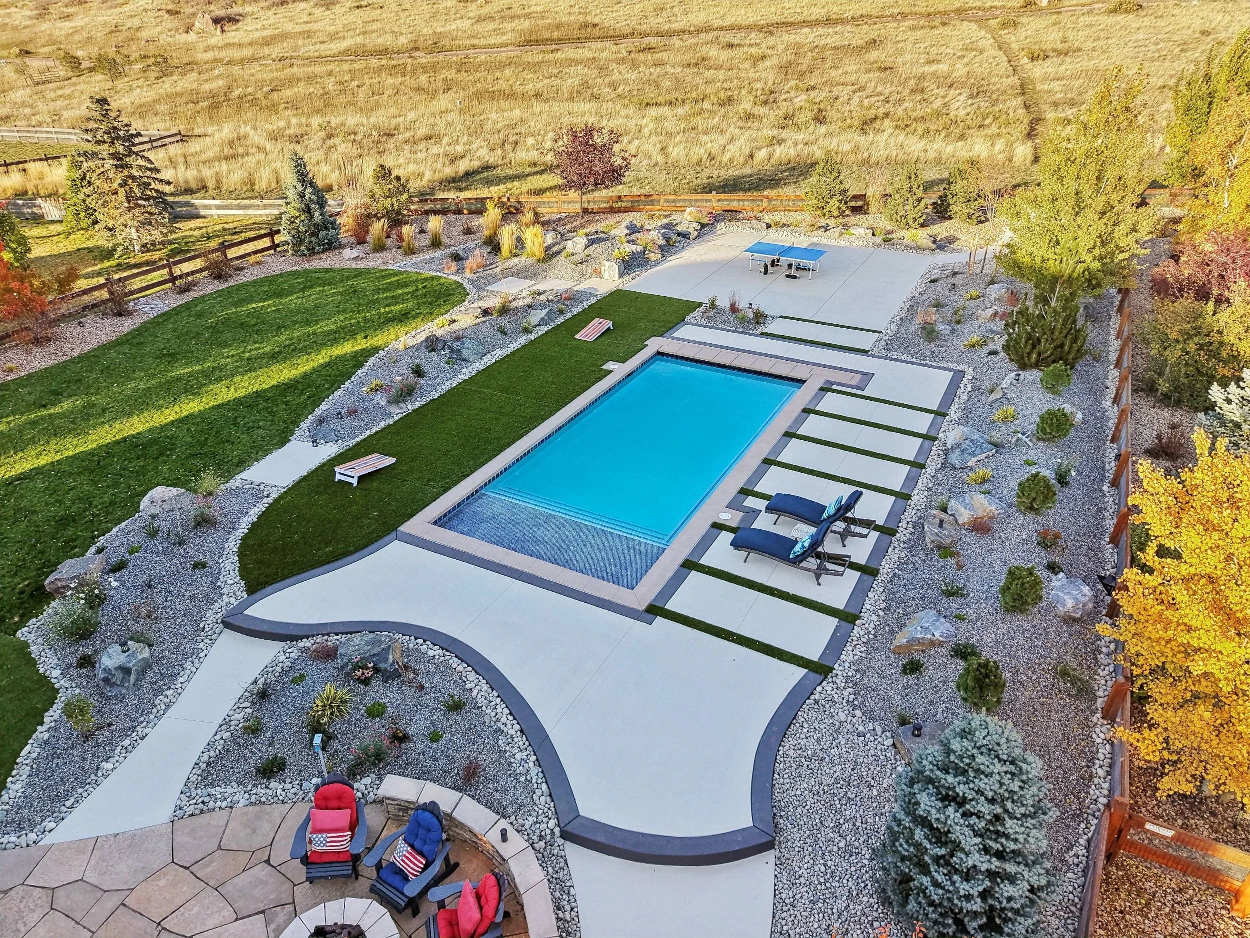 Patio with pool and lounge chairs surrounded by lush greenery in Cherry Hills Village, CO