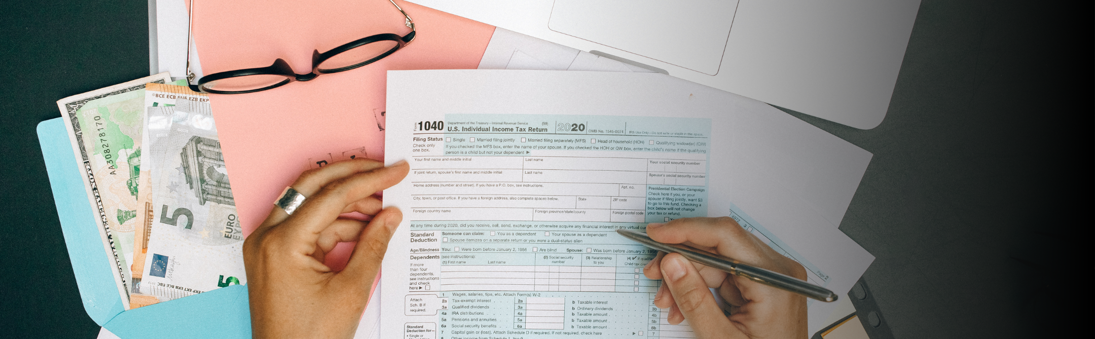 Photo of hands filling out a Form 1040 for US Taxes