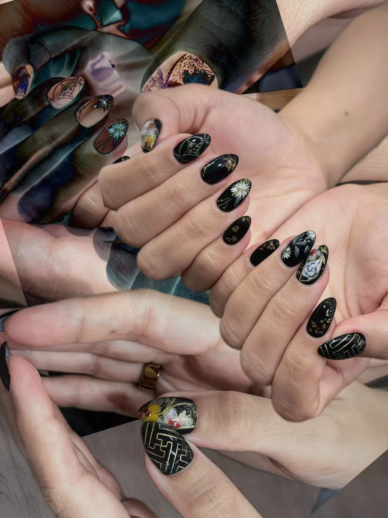 Intricate black nail art featuring detailed hand-painted illustrations, delicate gold accents, and artistic patterns.