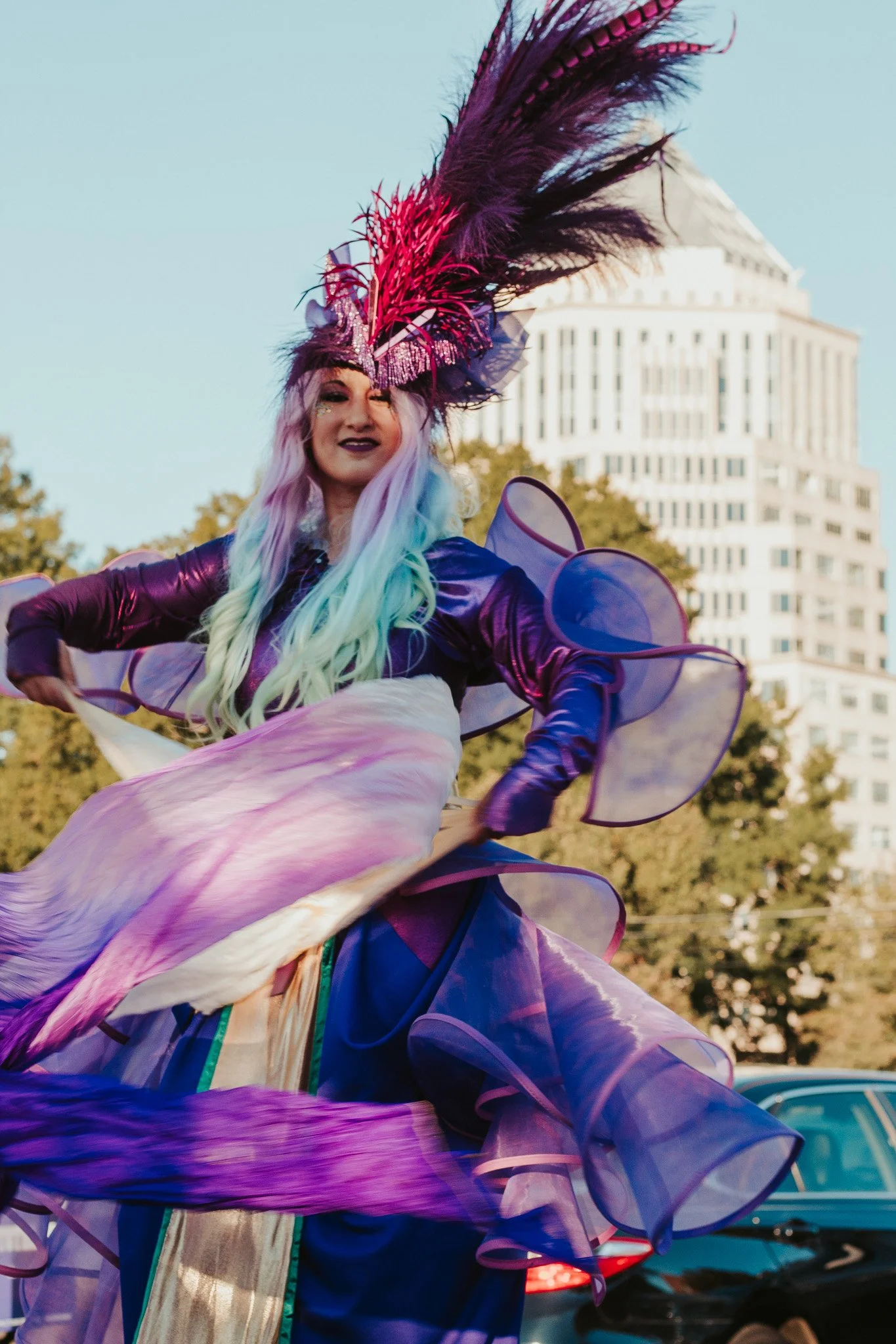 Stilts theatrical performer in shiny costume on hoop in city of Charlotte.