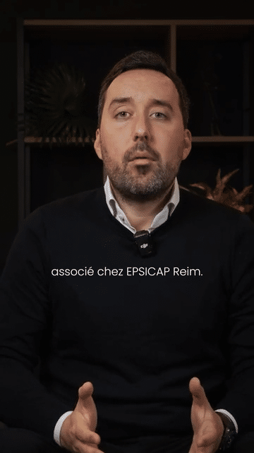 Image animée d'un homme assis devant une étagère avec des livres et des décorations, en train de parler dans le studio podcast