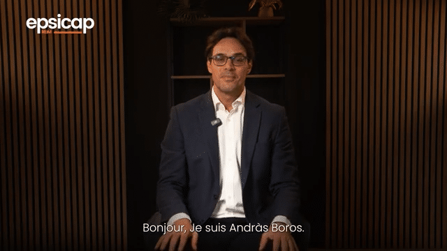 Image animée d'un homme assis devant une étagère avec des livres et des décorations, en train de parler dans le studio podcast