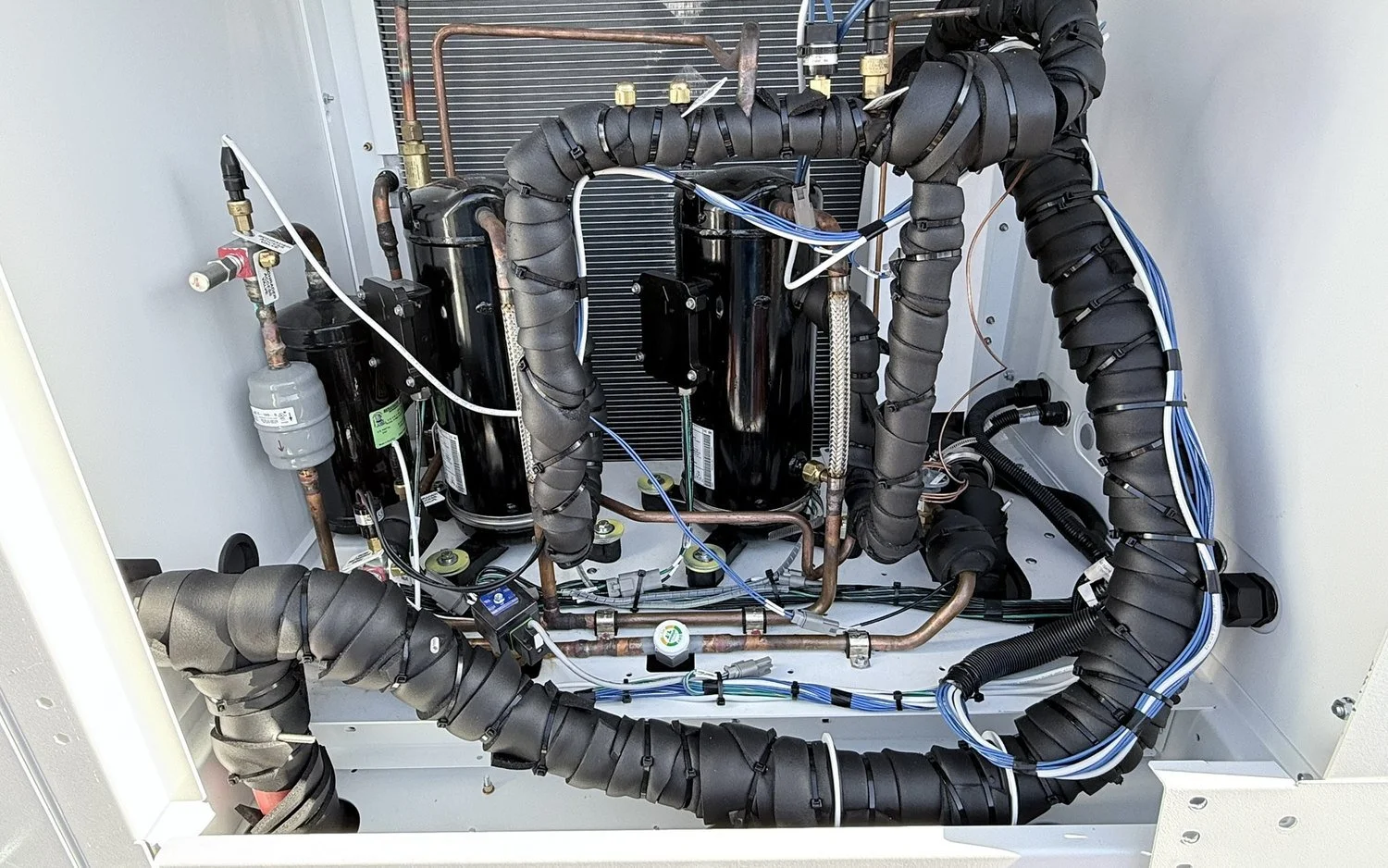 Inside a chiller cabinet: scroll compressors, insulated suction lines and control wiring