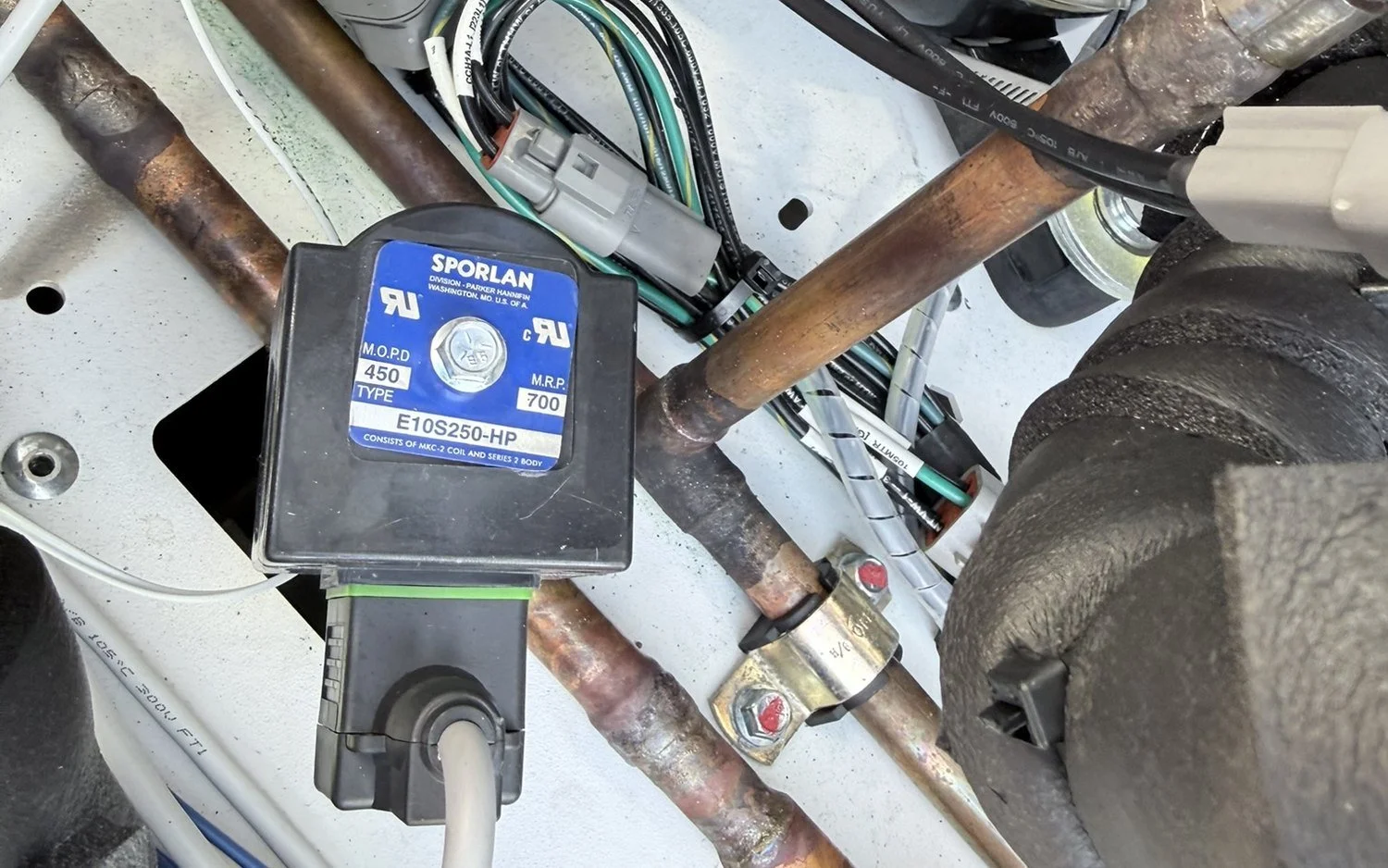 A Sporlan solenoid valve and copper refrigerant piping inside a chiller cabinet
