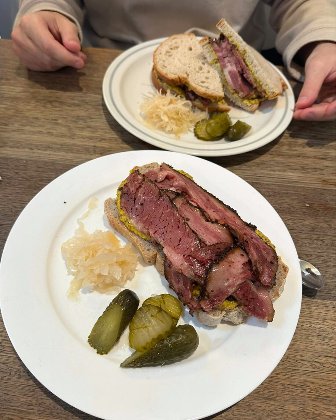 Zaidy's pastrami at a cafe with a side of pickles